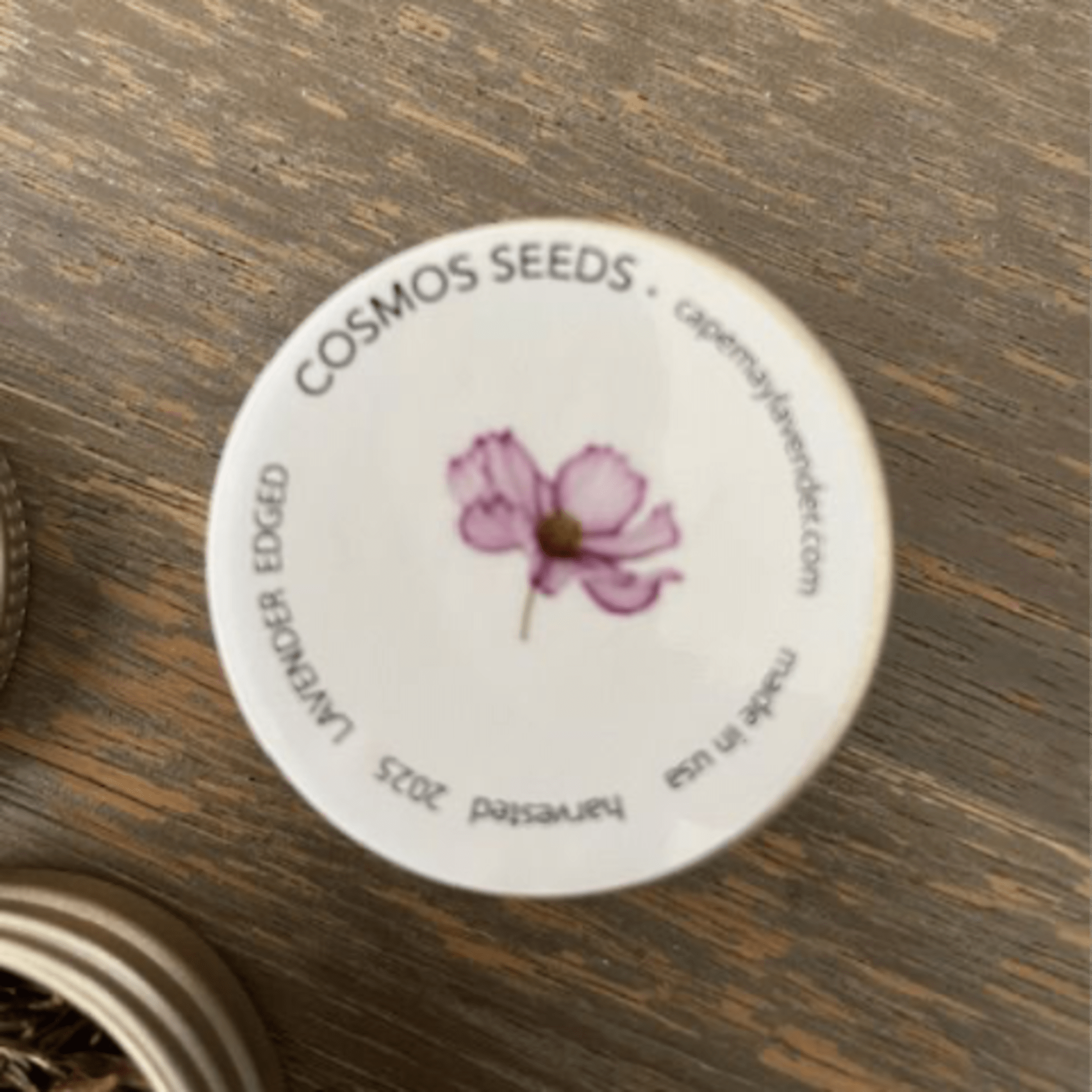 Round seed packet lid with a pink flower illustration