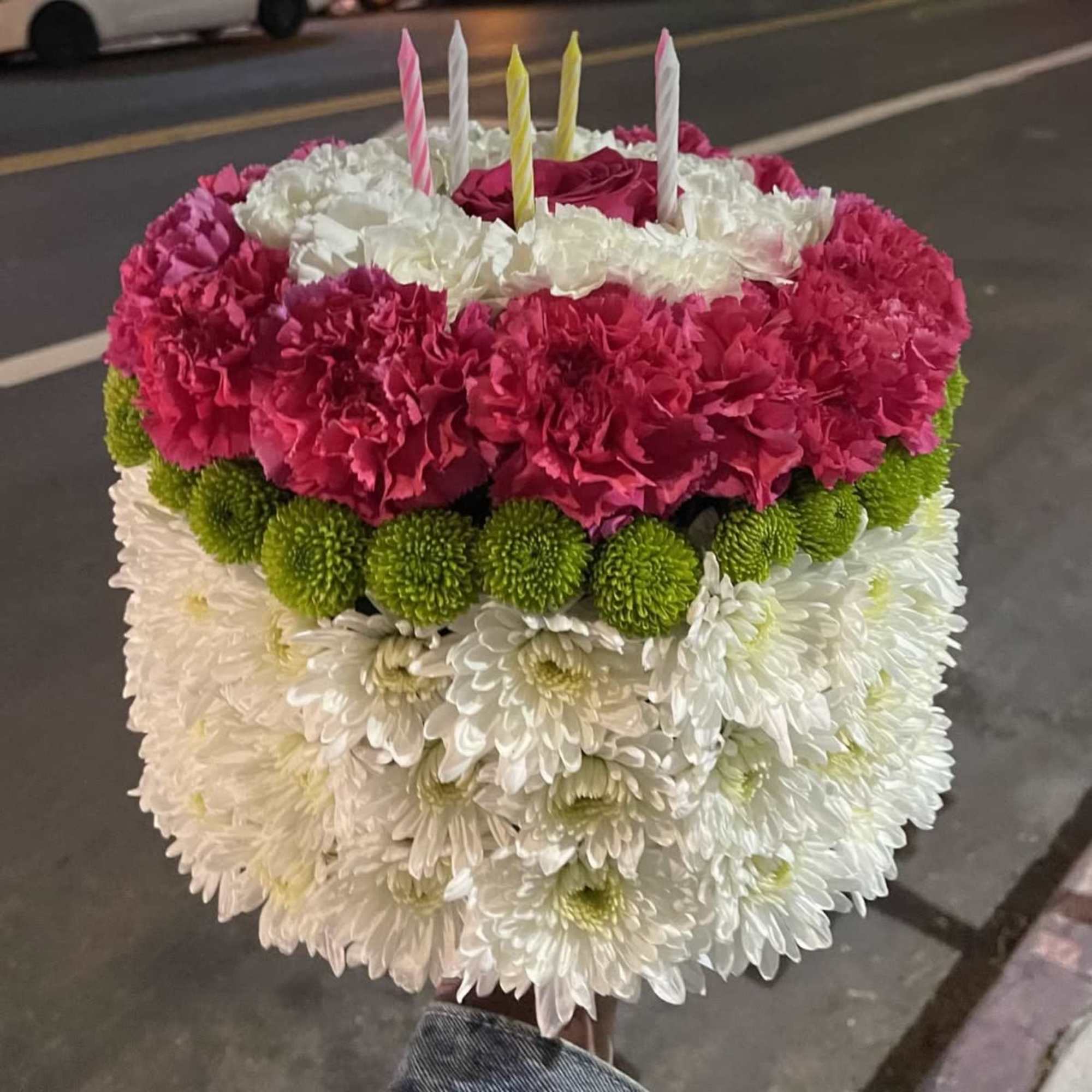 A delightful floral arrangement designed to look like a festive birthday cake!