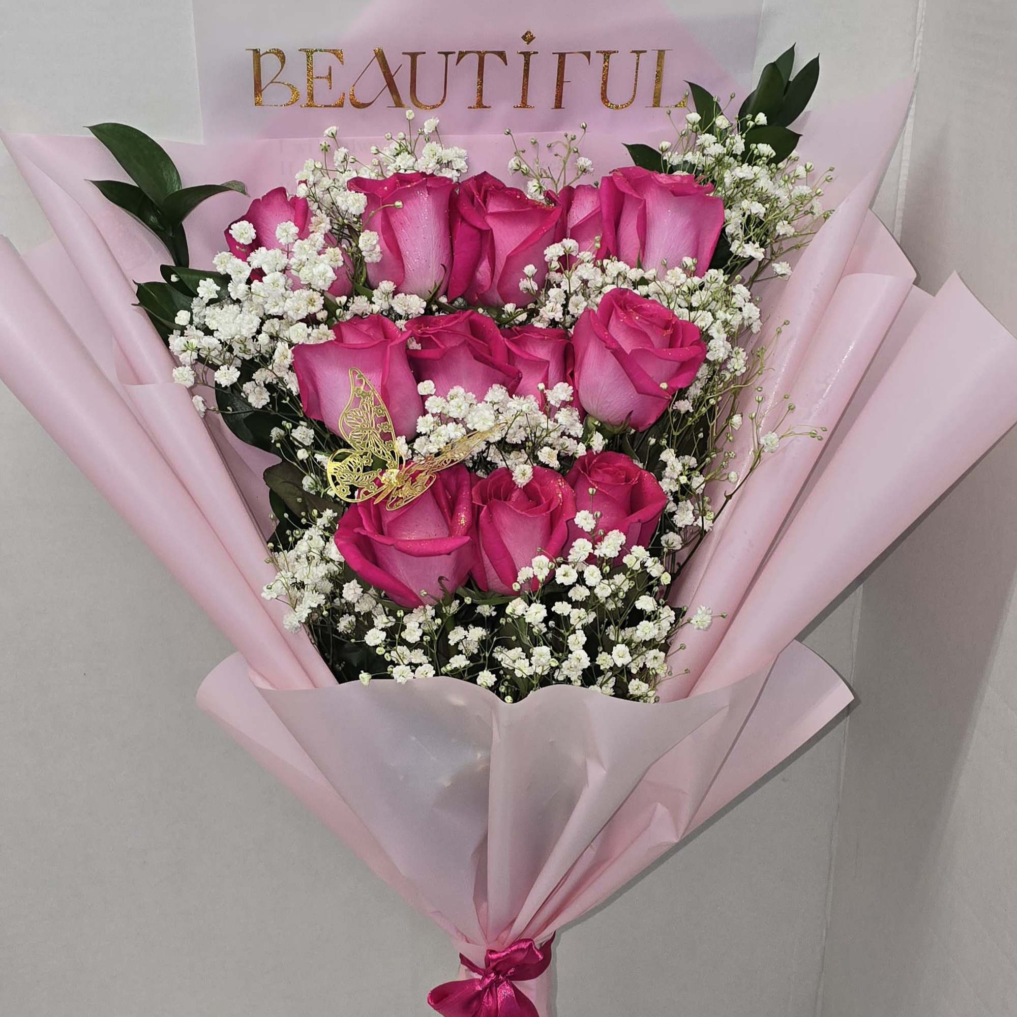 Bouquet of pink roses with baby's breath in pink wrapping