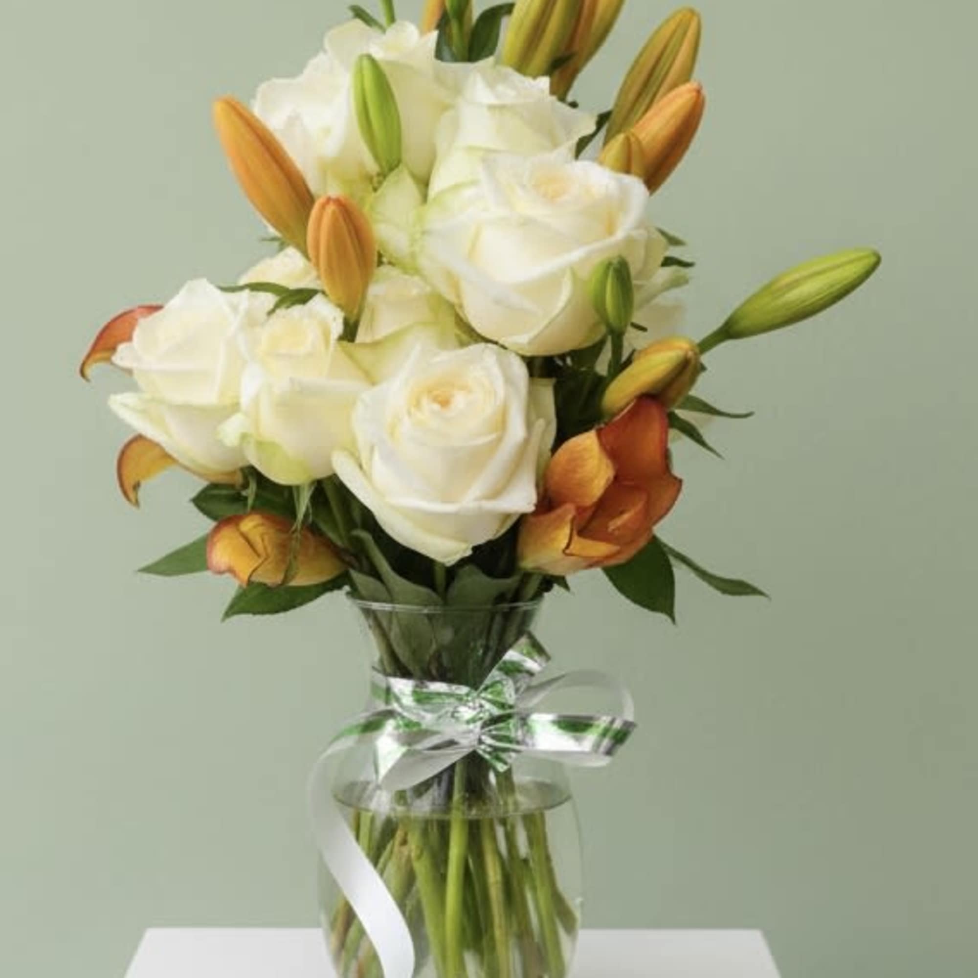Creamy white roses meet warm orange and sunny yellow lilies in a