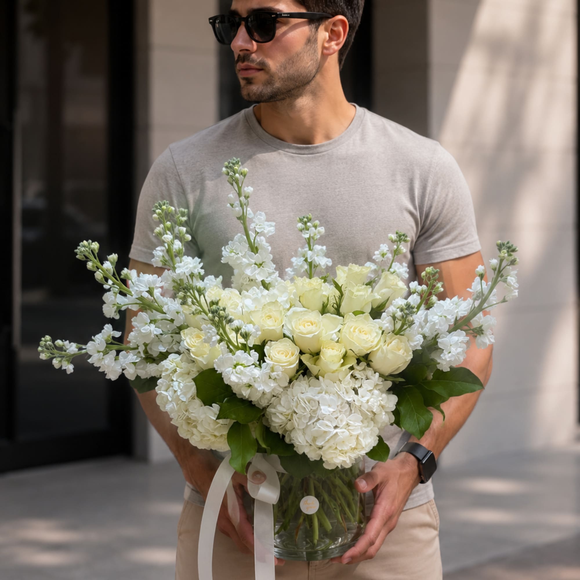 Creamy white roses and full white hydrangeas form a serene, rounded bouquet