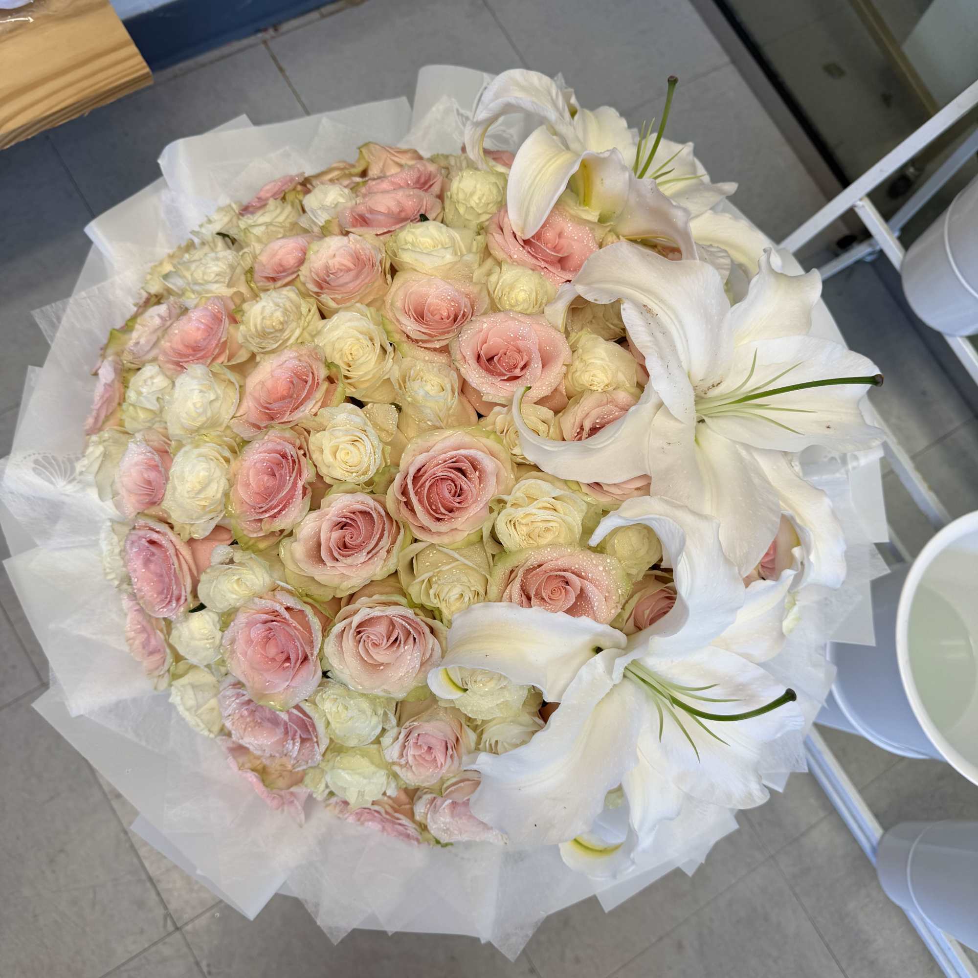 A cloud of blush pink and creamy white roses crowned with large