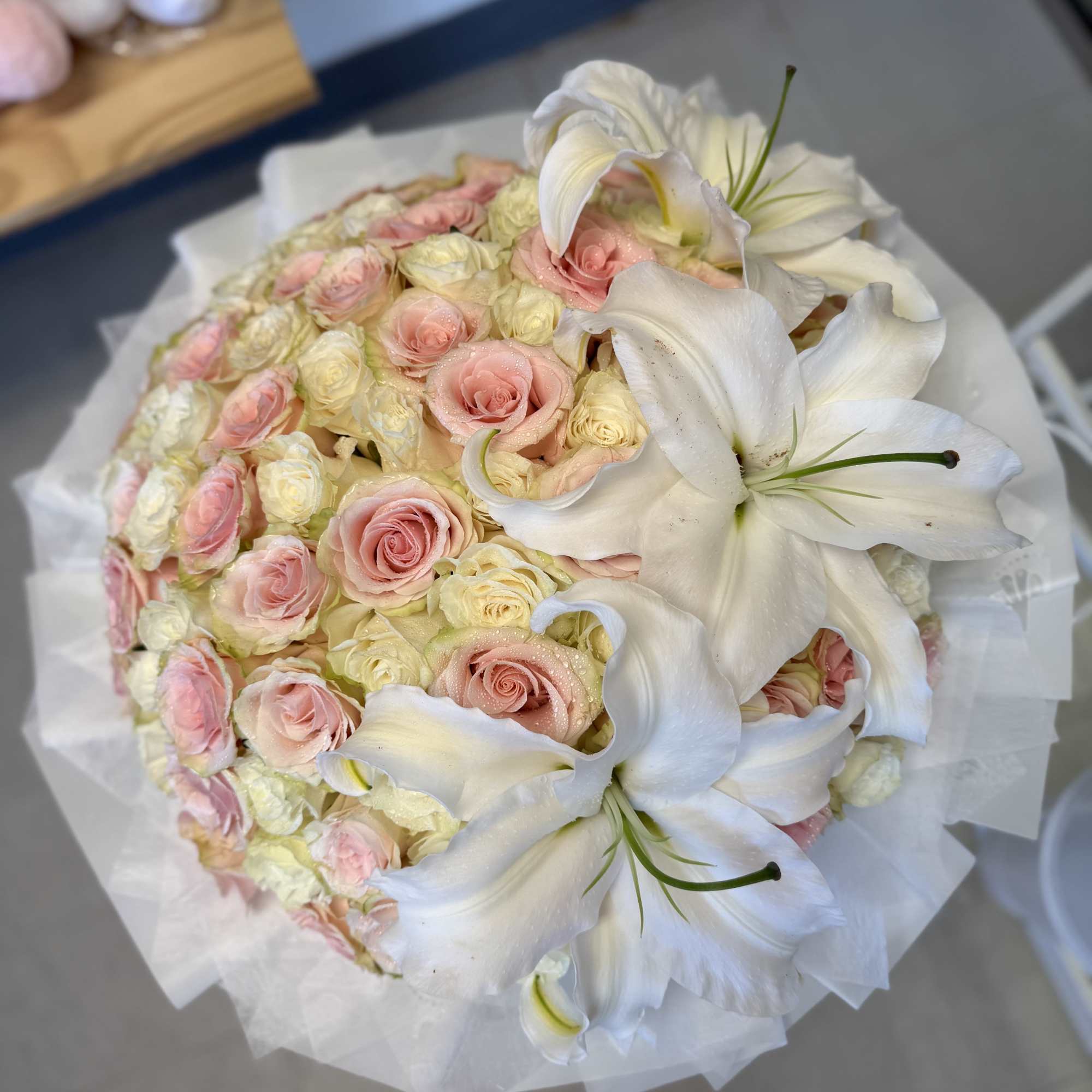 A cloud of blush pink and creamy white roses crowned with large