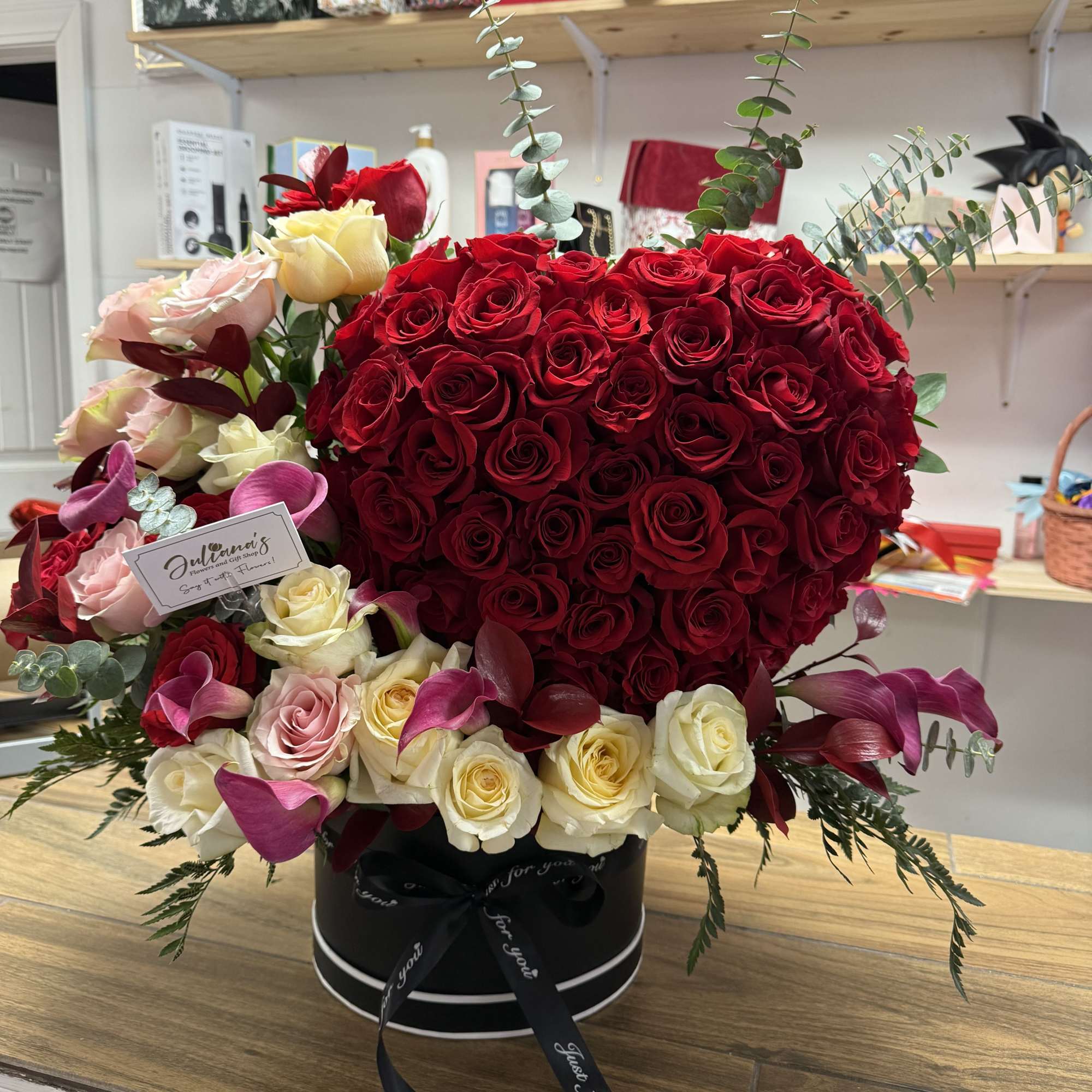 A striking heart-shaped cluster of deep red roses crowns this romantic flower