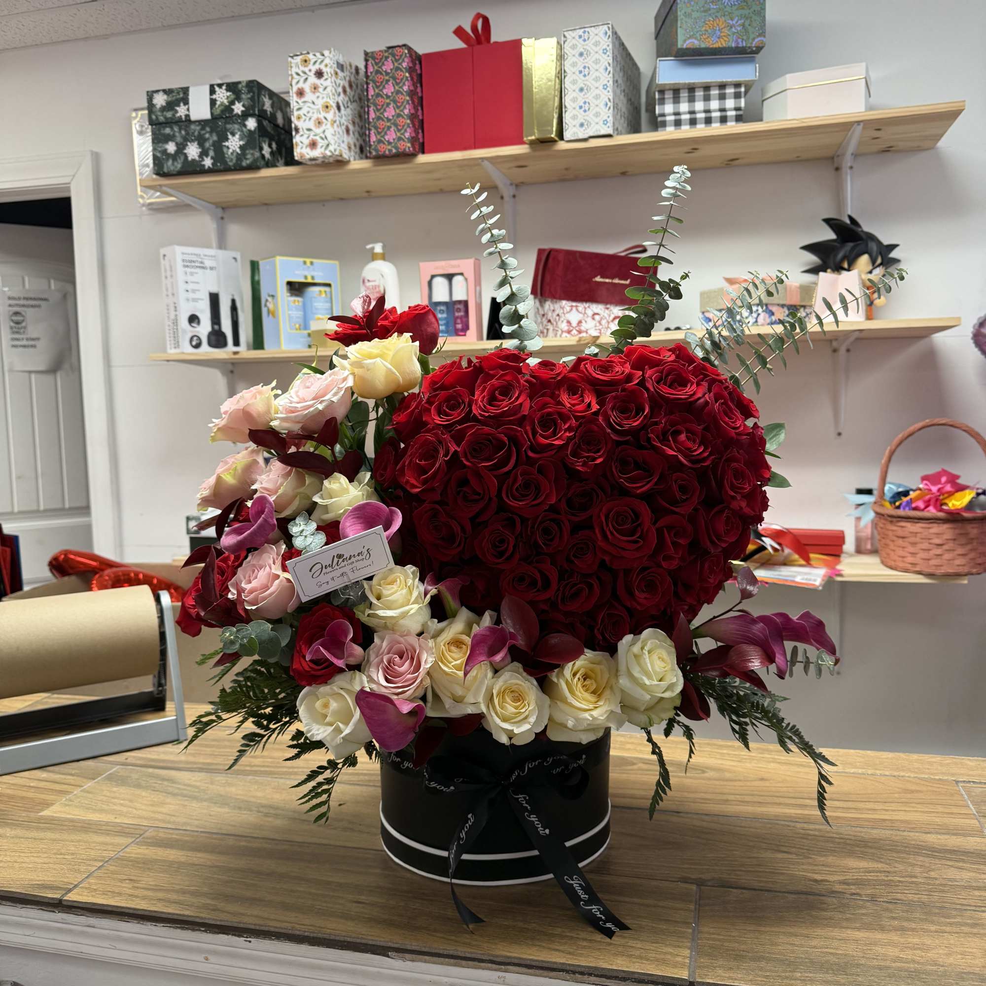 A striking heart-shaped cluster of deep red roses crowns this romantic flower