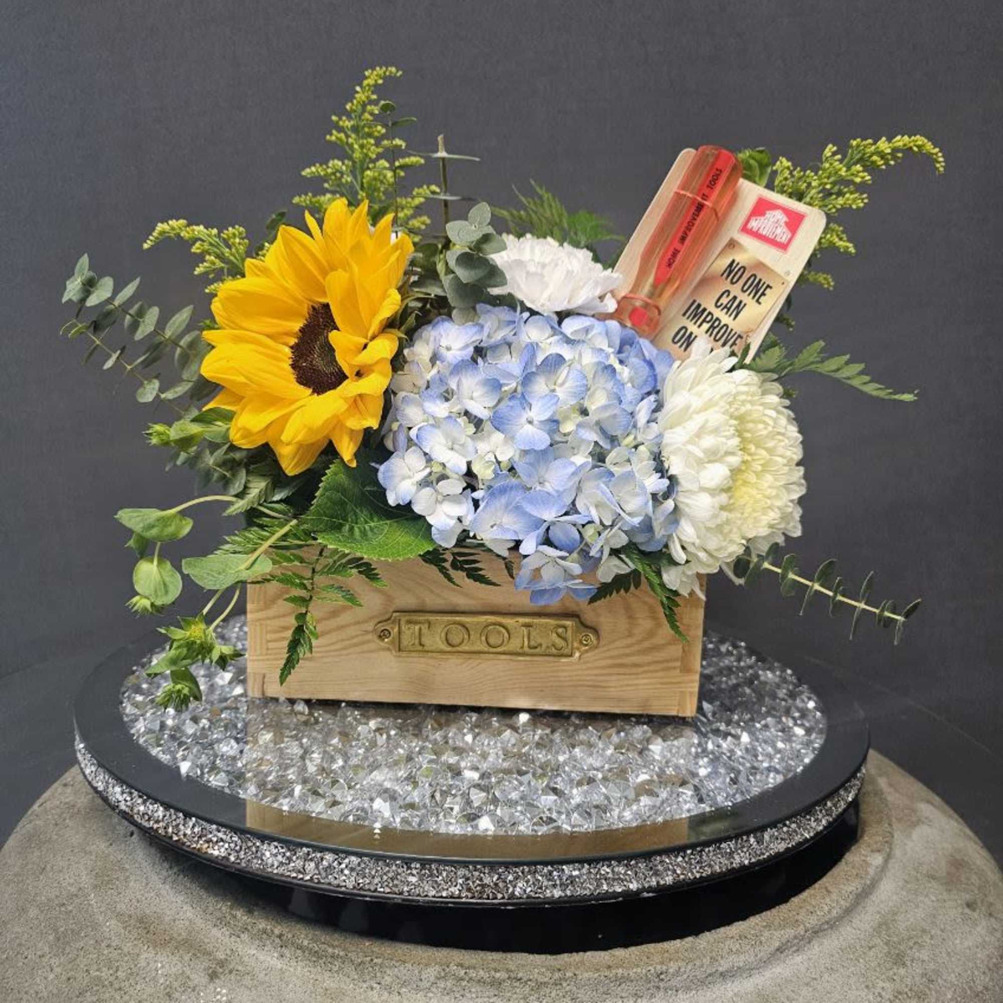 A bold golden sunflower takes center stage in this cheerful flower arrangement