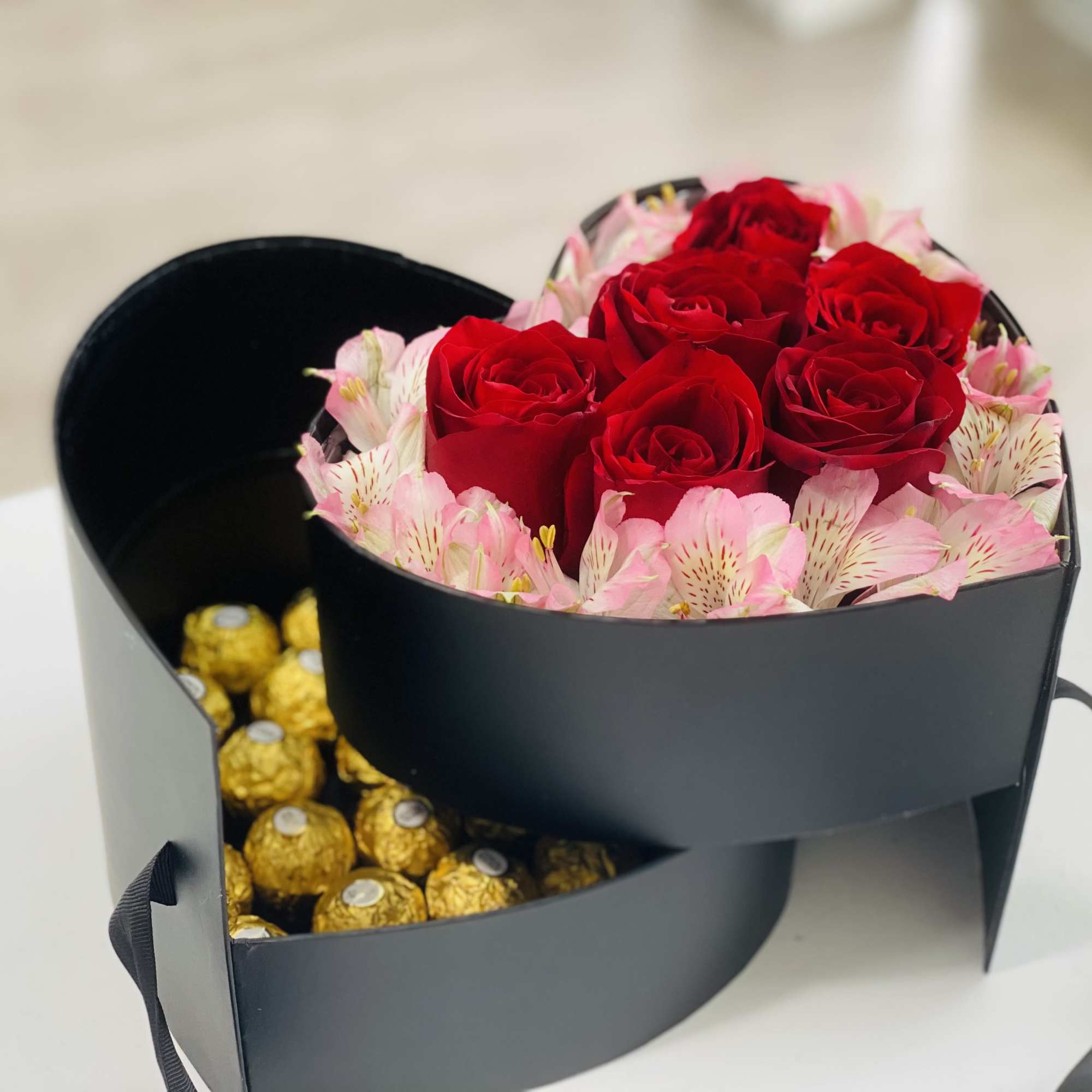 Heart-shaped box with red roses, pink flowers, and gold chocolates