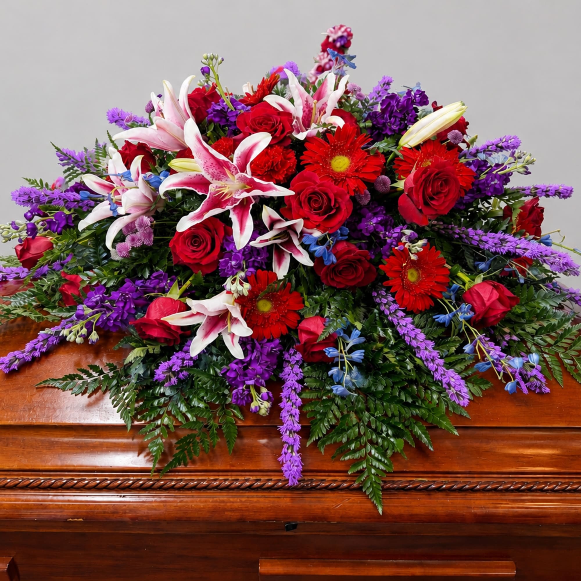 A broad, cascading casket spray made to convey deep respect and comfort