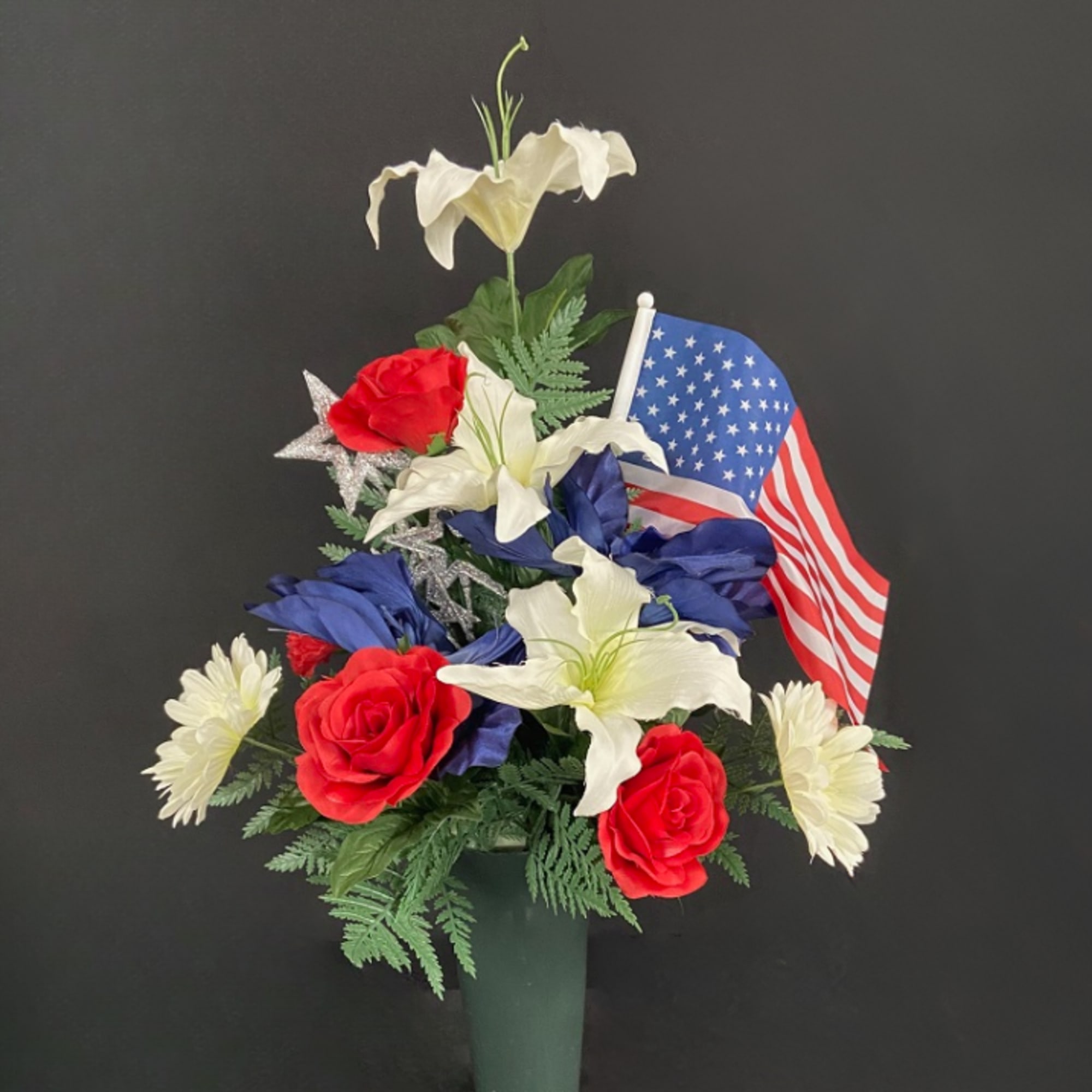 Red, white, and blue floral arrangement with an American flag in a vase