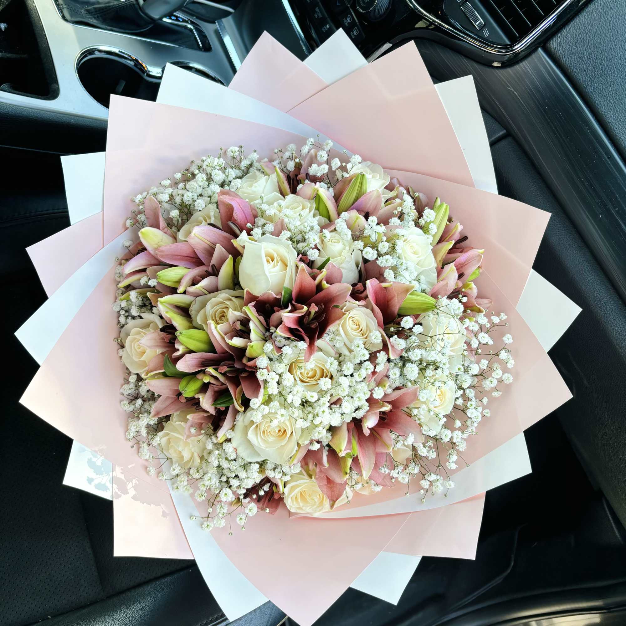 Bouquet of pink lilies and cream roses wrapped in pastel paper