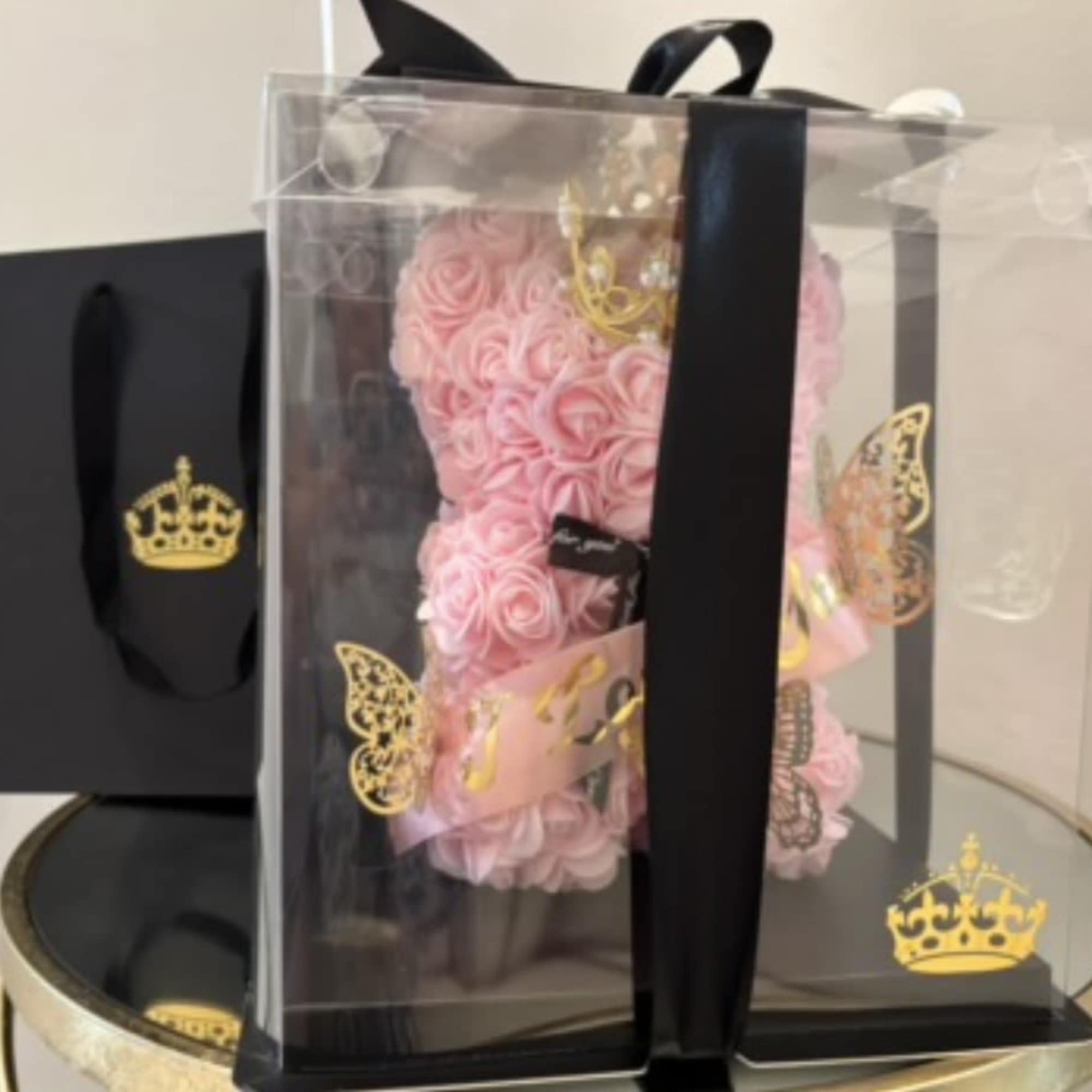 Pink rose teddy bear in a clear gift box with black ribbon