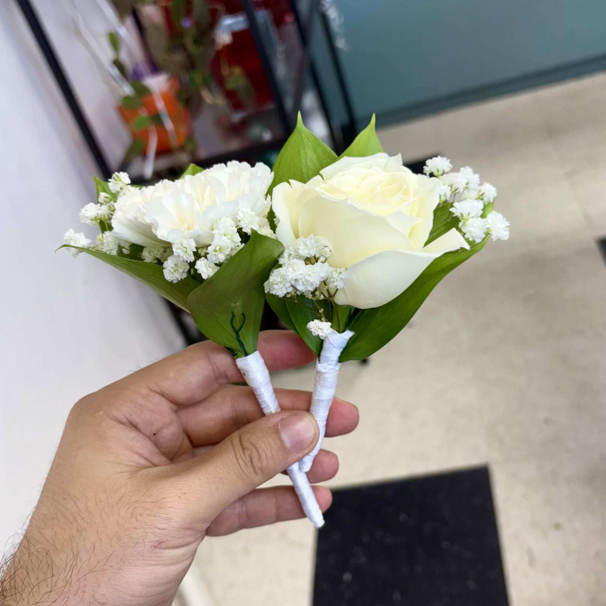 Classic and modern boutonnieres featuring hand-selected roses and refined greenery. A distinguished