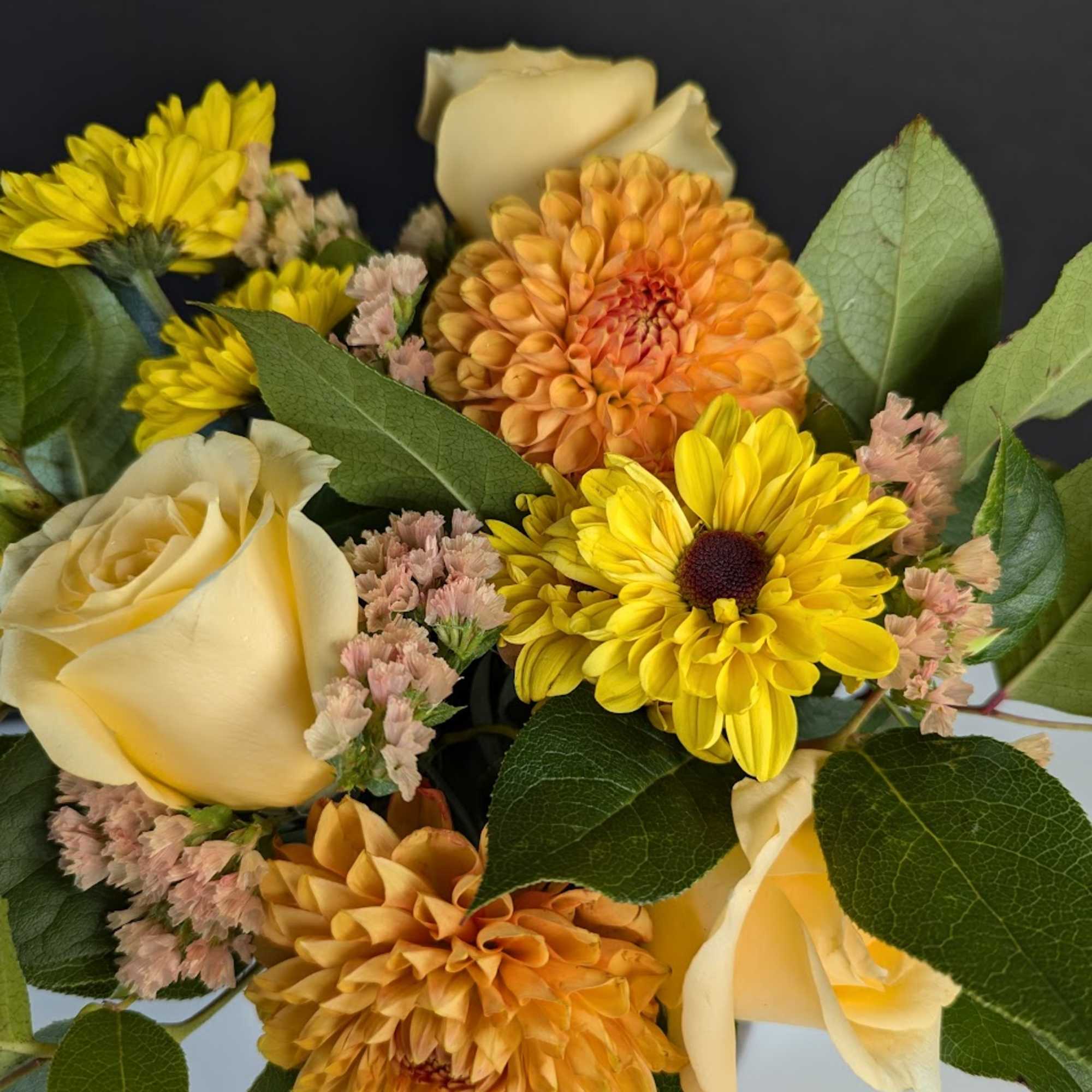 Bouquet of yellow daisies, cream roses, and orange dahlias
