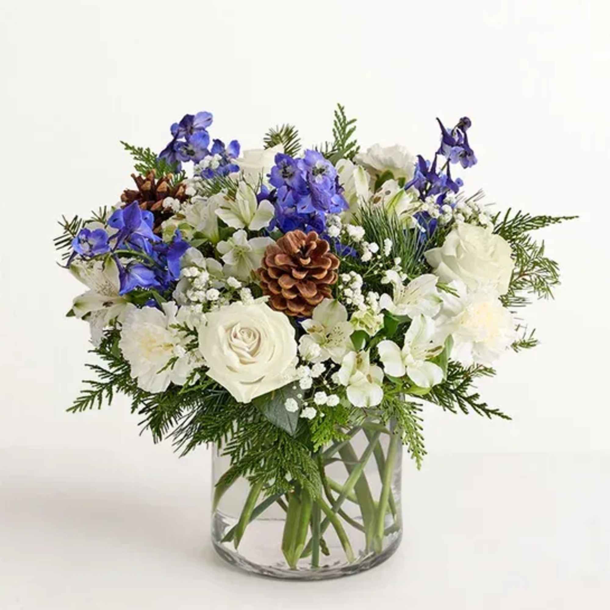 White and blue floral arrangement in a clear glass vase