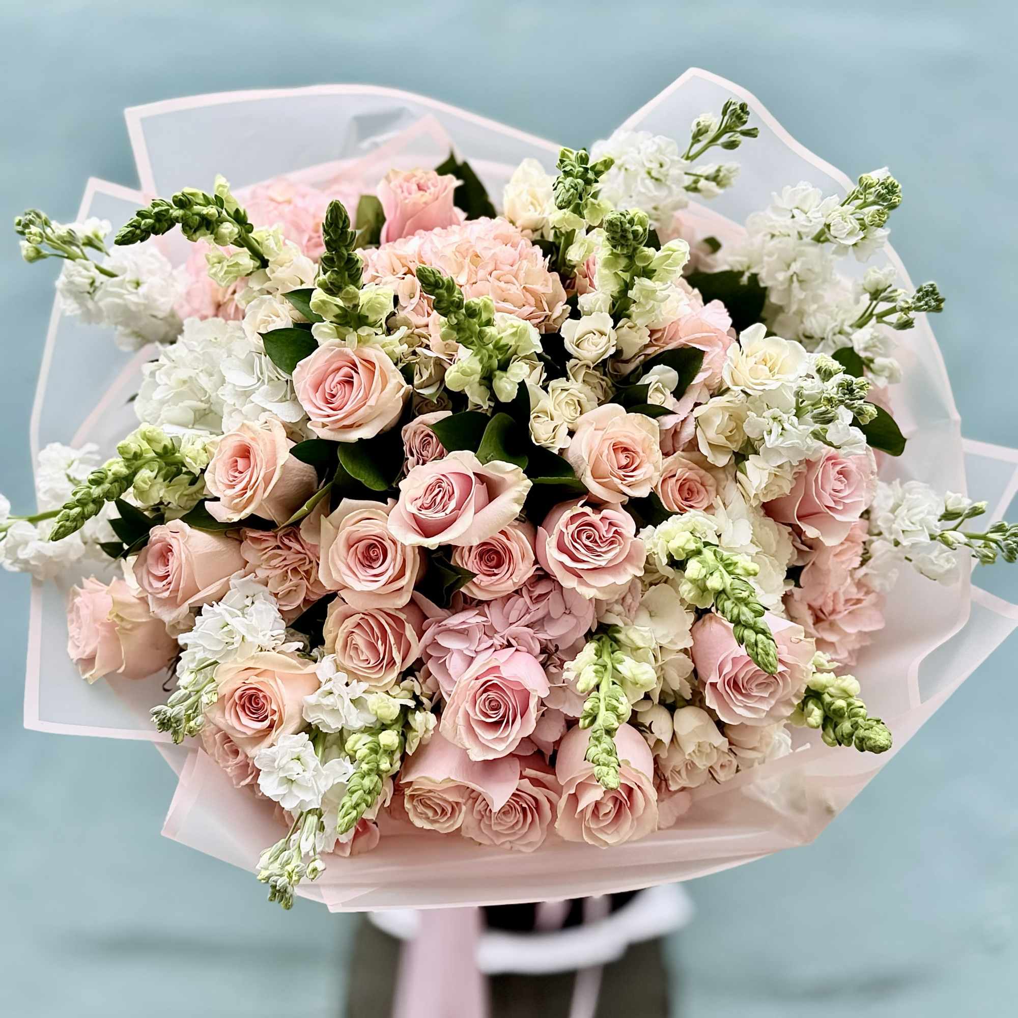 A cloud of pale pink roses takes center stage in this hand-tied