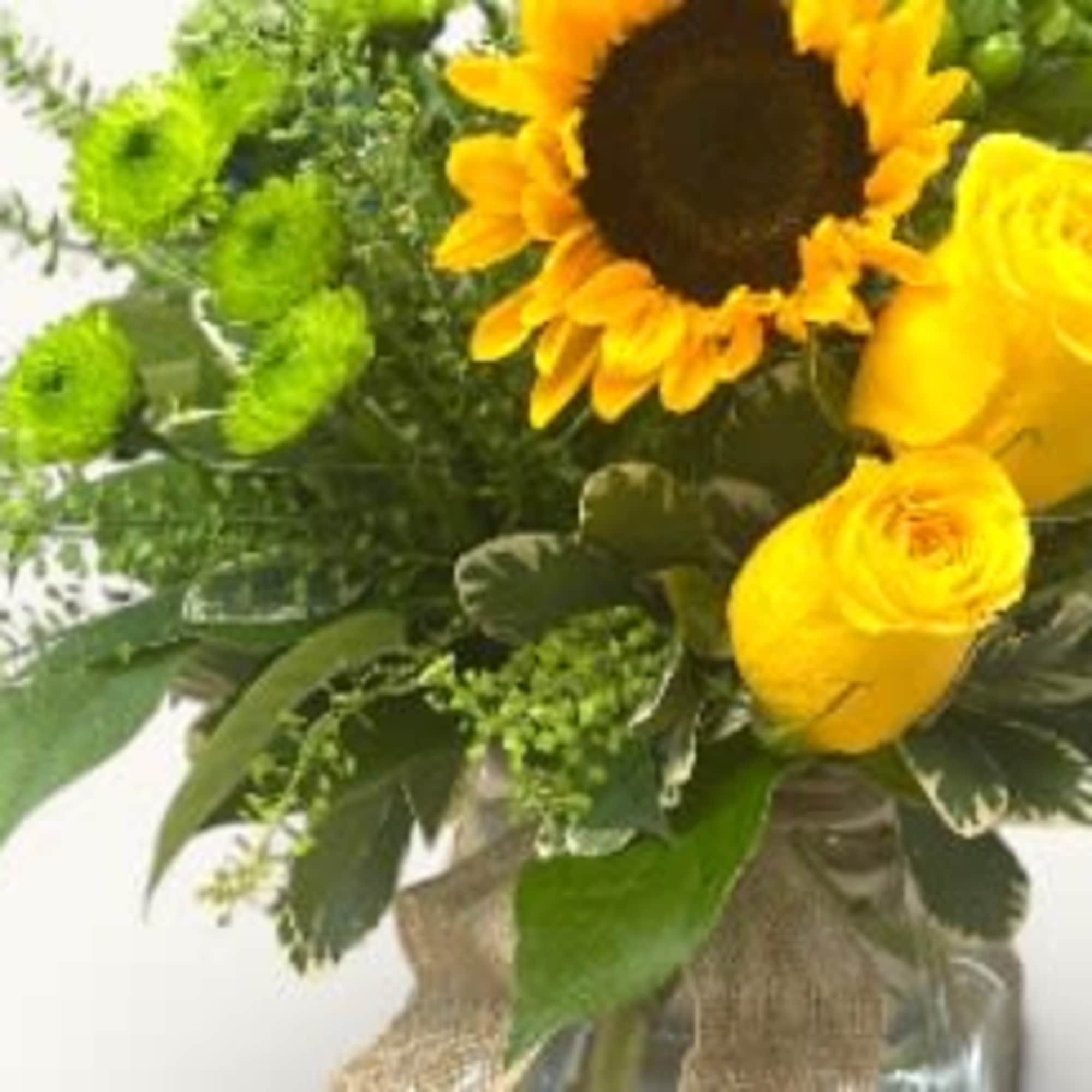 Radiant yellow roses and cheerful sunflowers, complemented by vibrant green mums, create