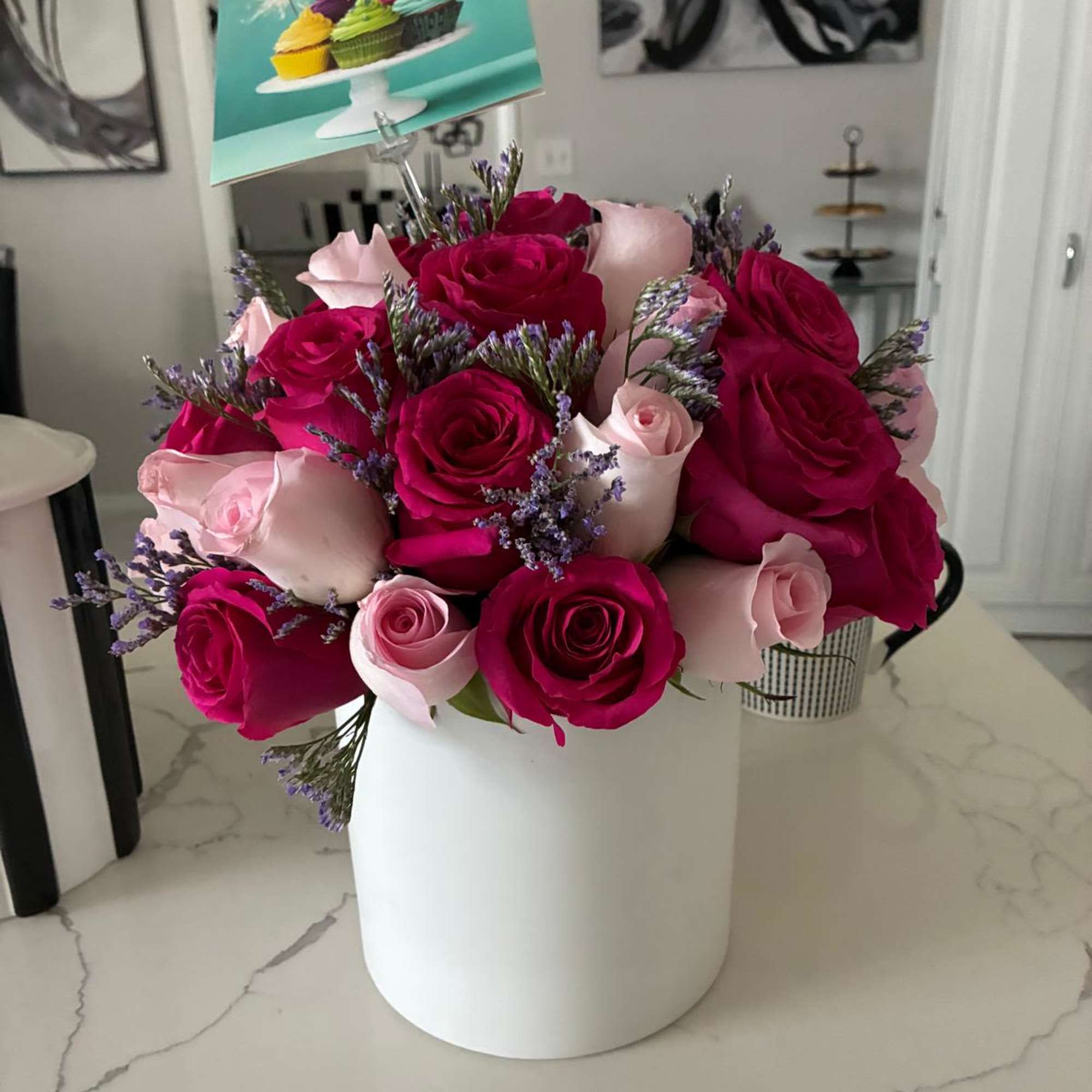 Bouquet of pink and magenta roses in a white hat box with a birthday card
