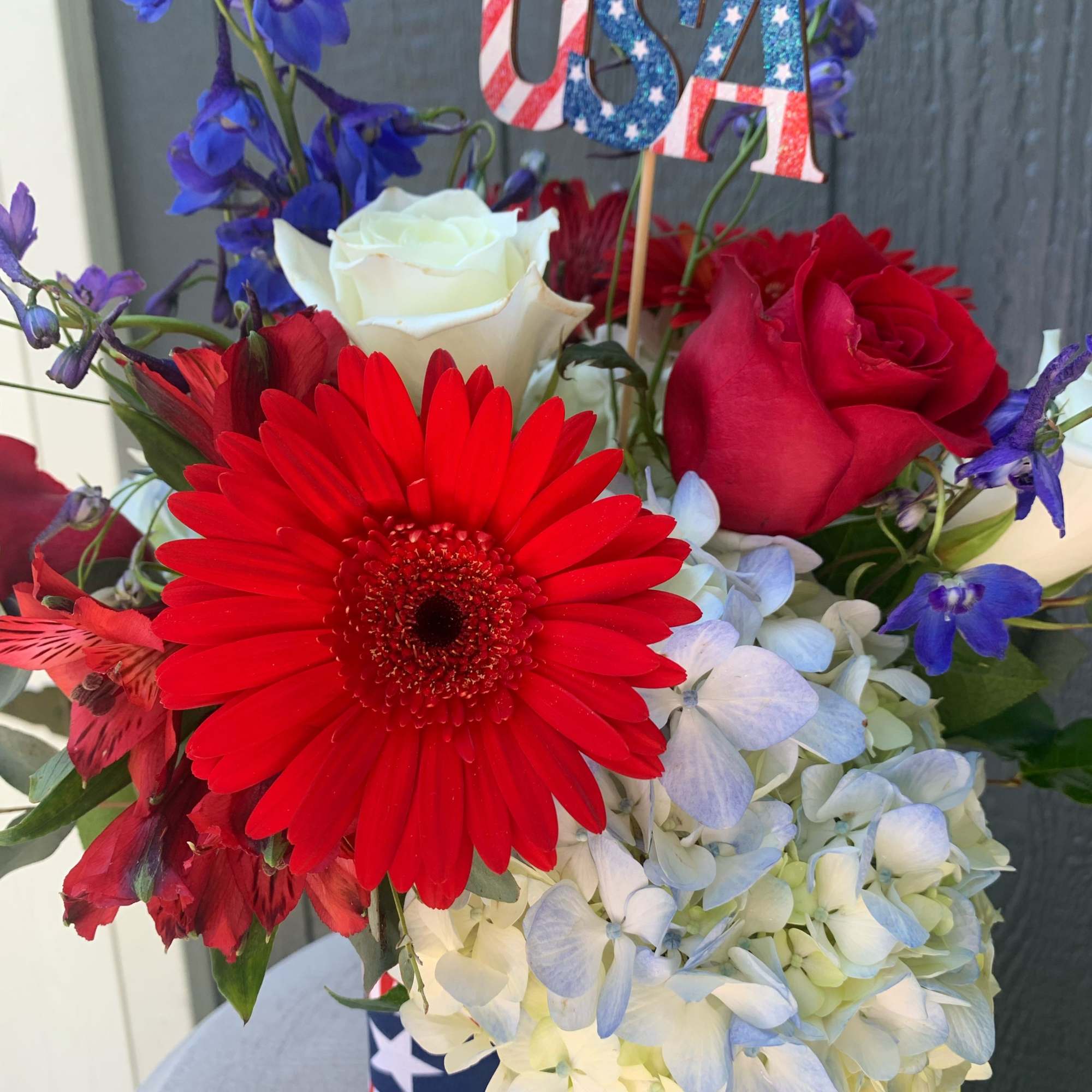 Red, white, and blue floral arrangement with a USA topper