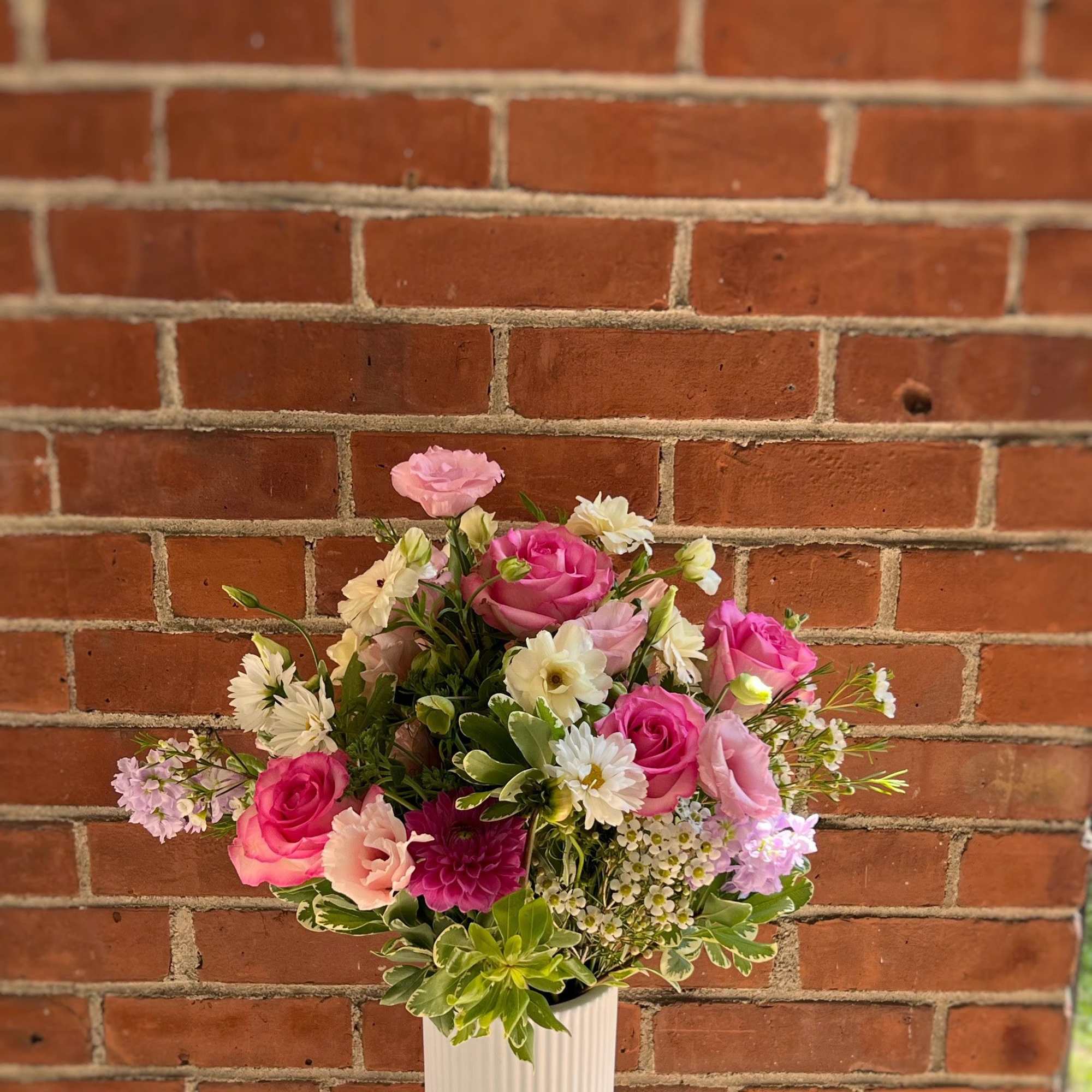 Pink and white mixed flower arrangement in a white vase
