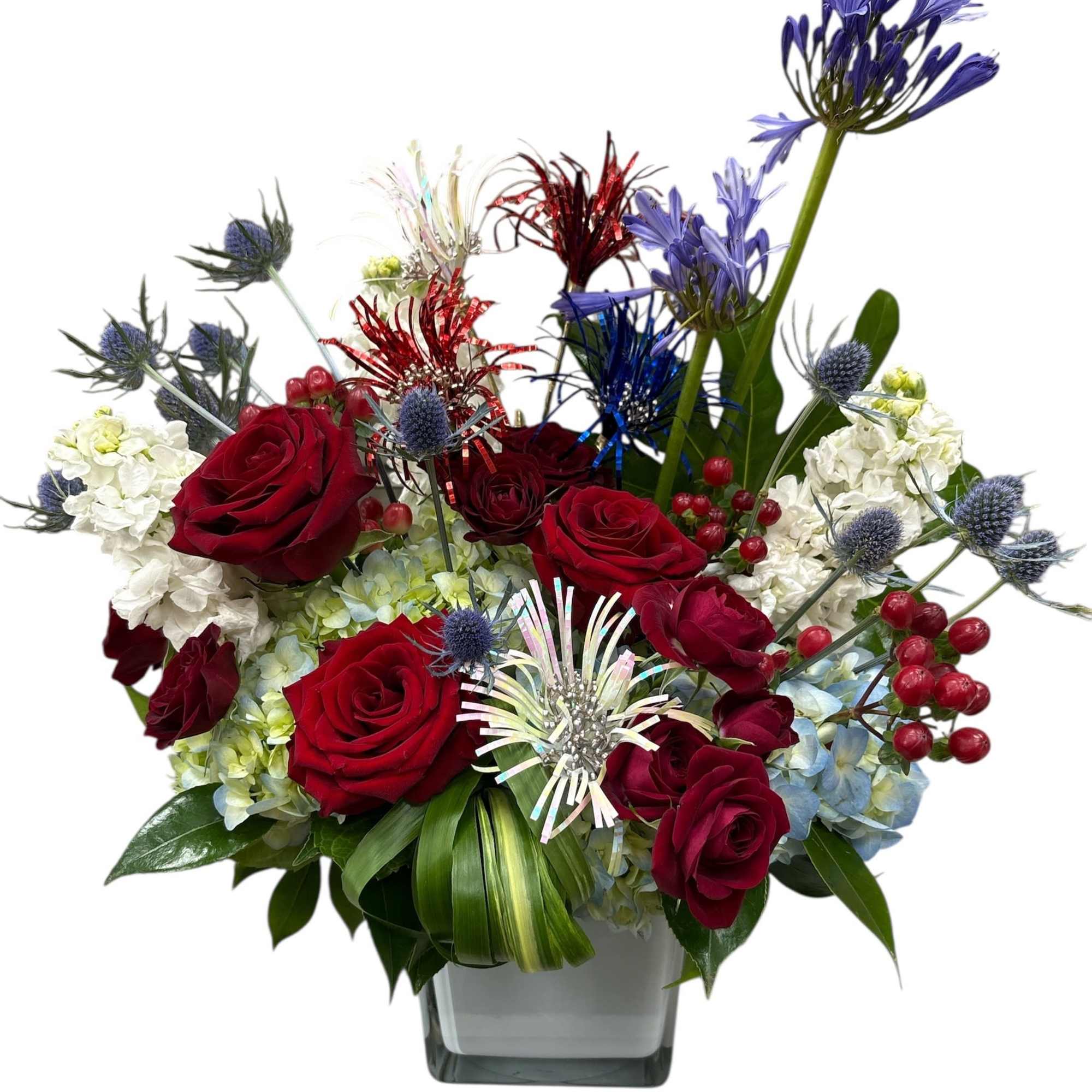 Mixed bouquet of red roses, white hydrangeas, and purple blooms in a glass vase