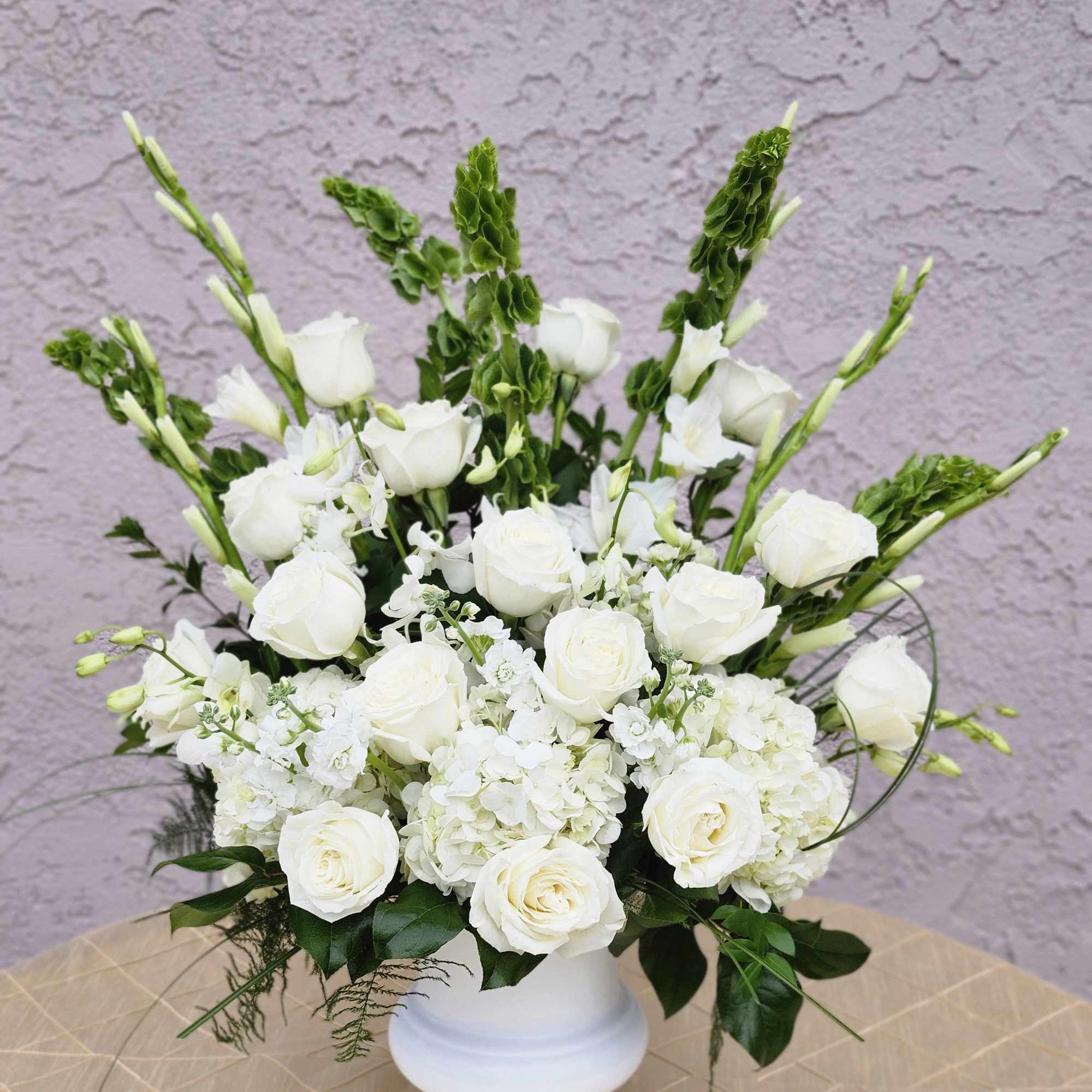 White roses and hydrangeas arranged in a white vase