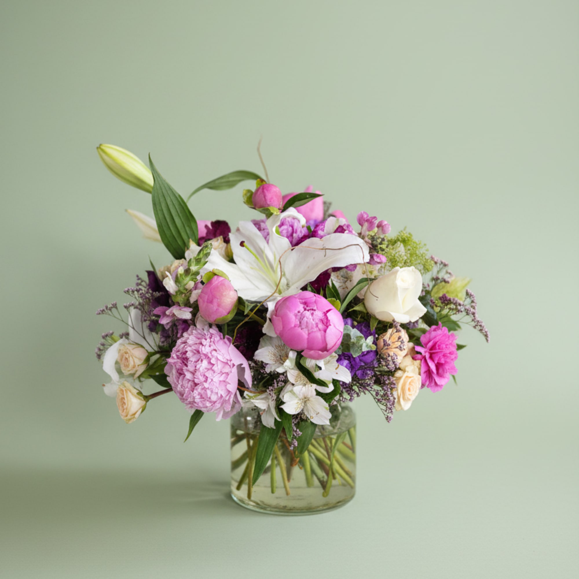 True peonies, elegant lilies, roses, and premium seasonal blooms gathered into a