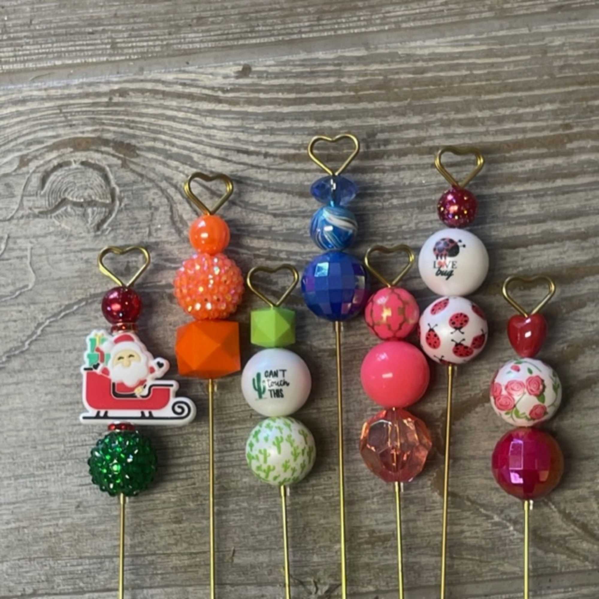 Colorful beaded picks with heart-shaped tops arranged on a wood surface