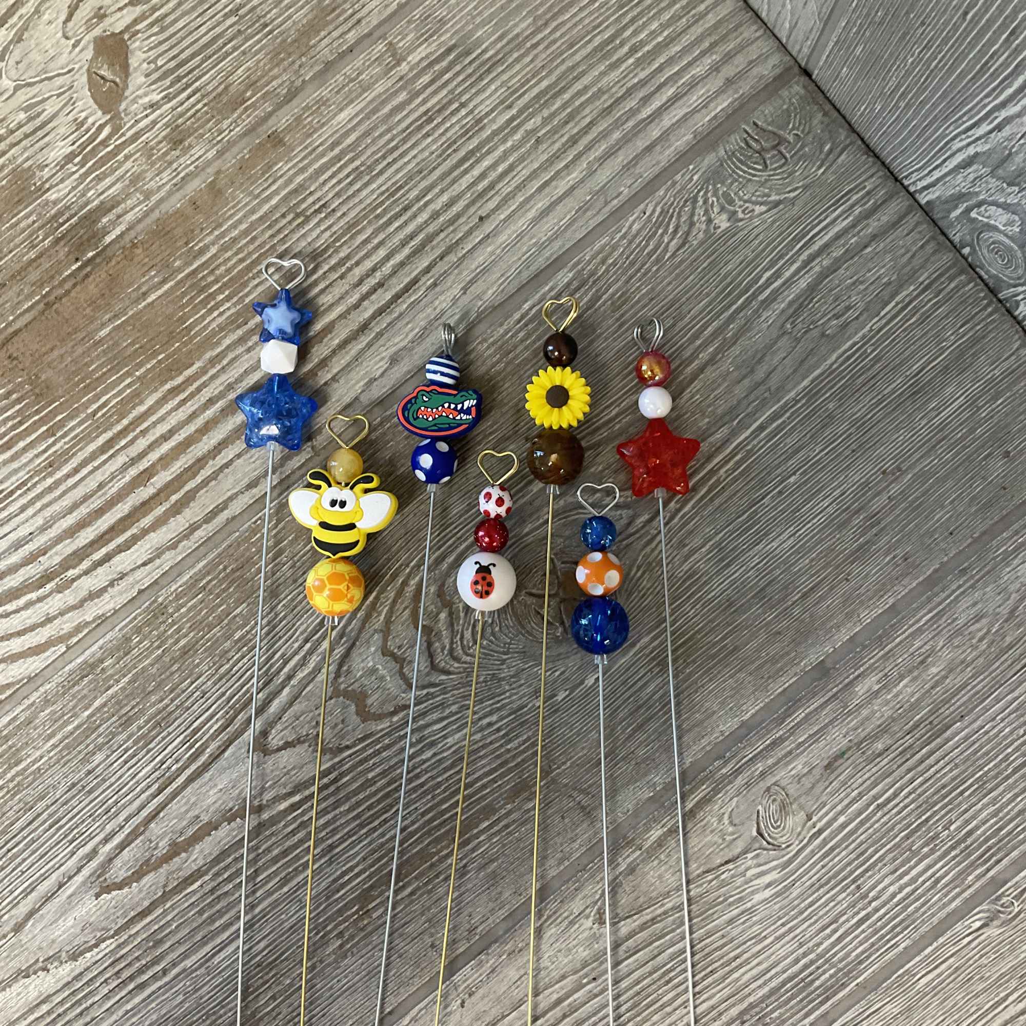 Decorative beaded picks with stars, a bee, a ladybug, and a sunflower