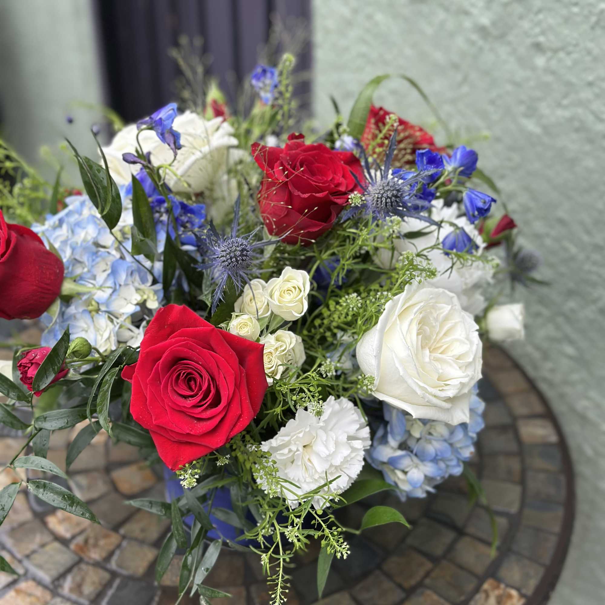 A bold red-white-blue centerpiece that reads both patriotic and celebratory, this flower