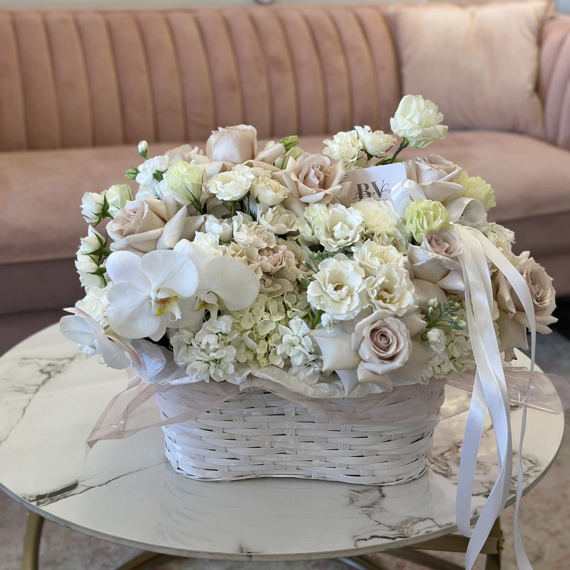 Cream and blush bouquet in a white basket with ribbon