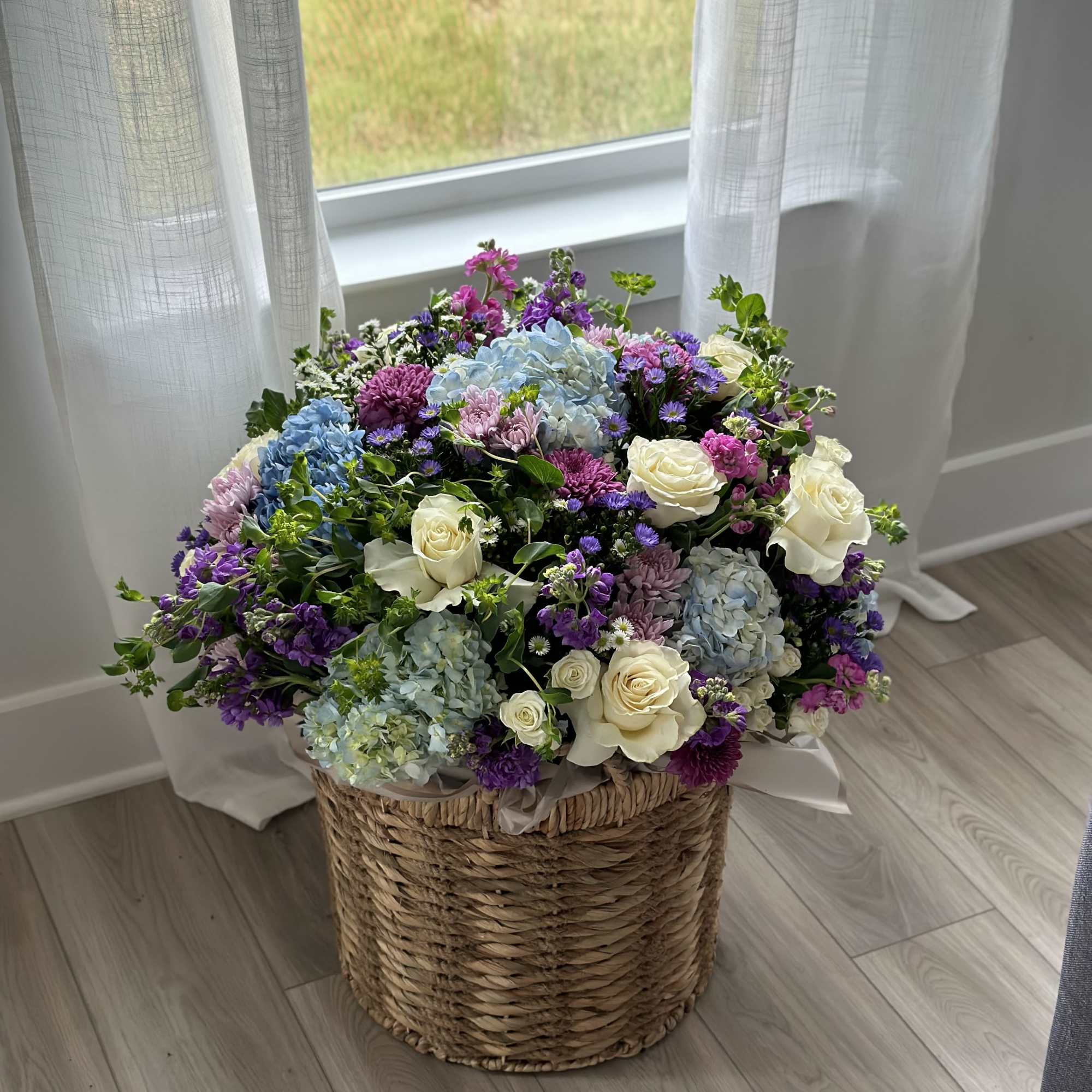 Large mixed flower arrangement in a woven basket