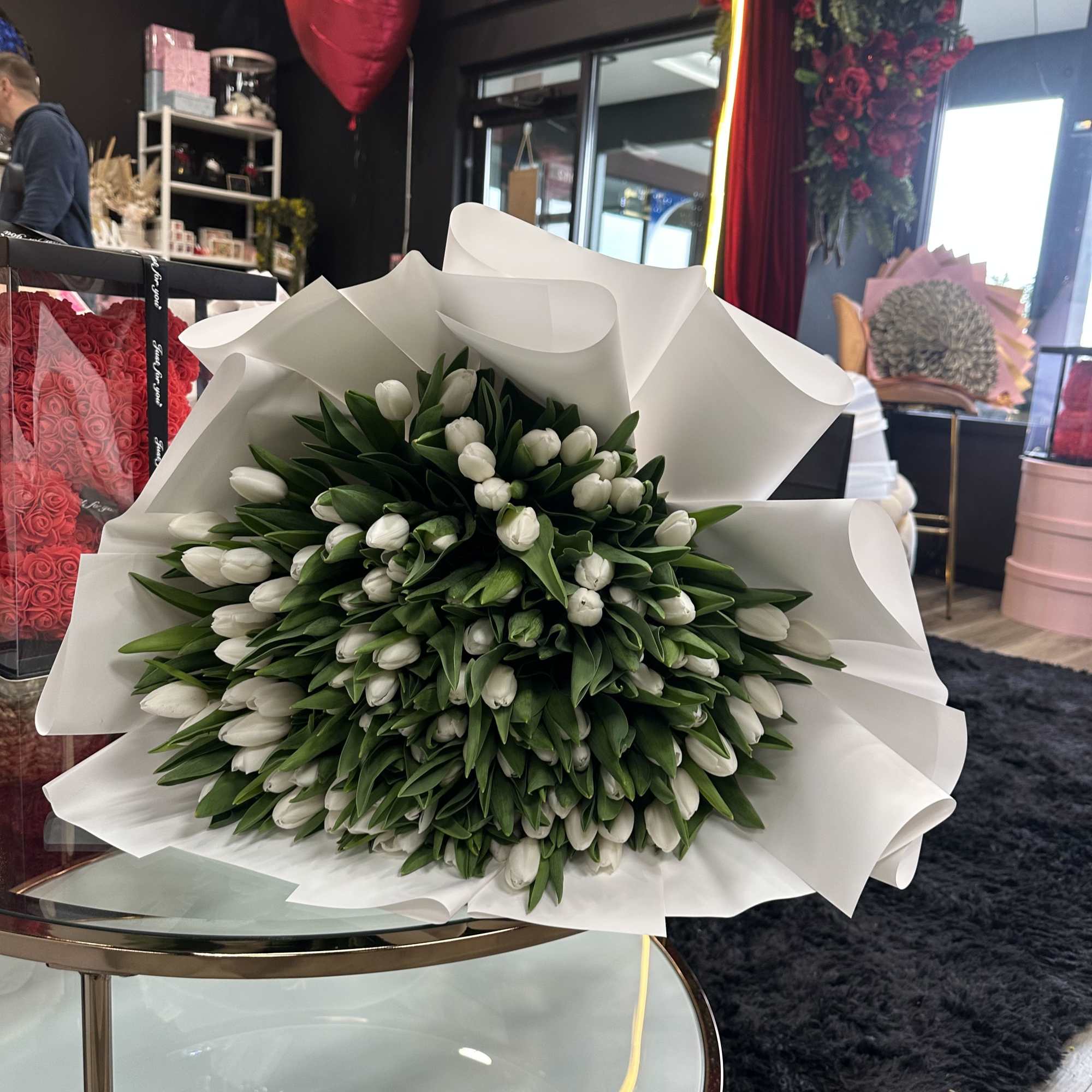This exquisite bouquet features 100 pure white tulips, meticulously arranged to create