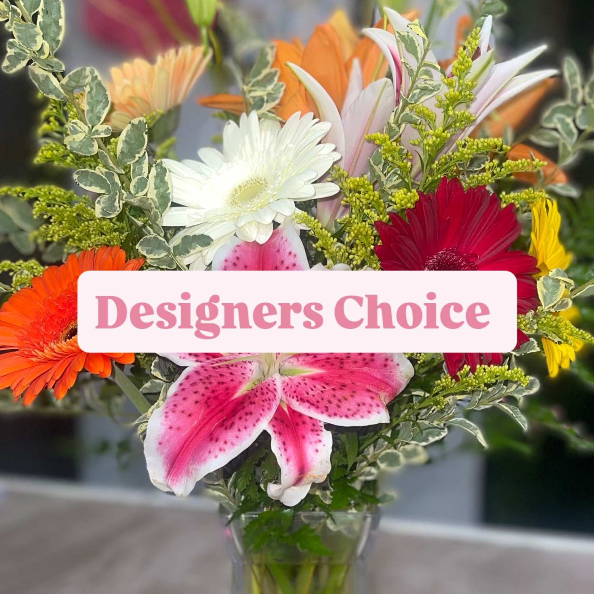 Mixed bouquet of lilies, gerbera daisies, and a pink lily in a glass vase