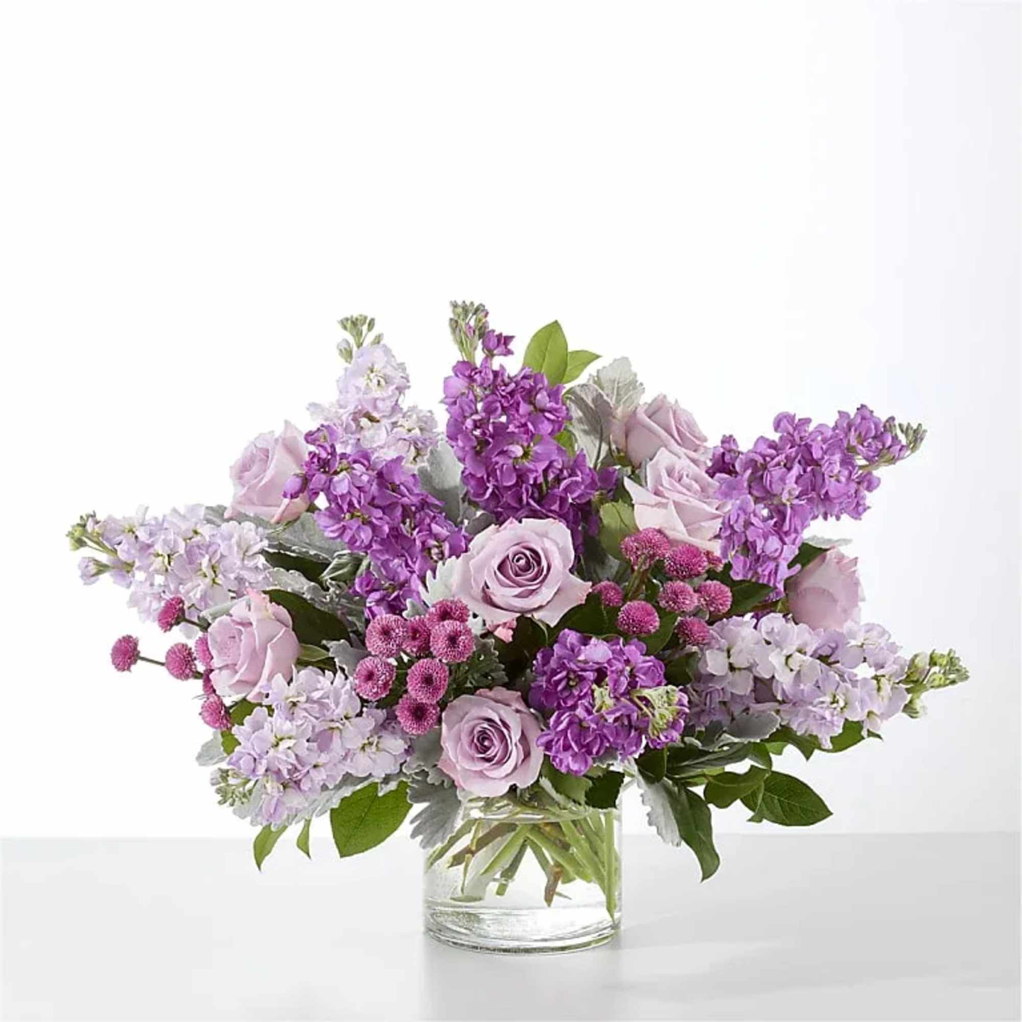Clusters of lavender roses sit among tall purple and lavender stock, accented