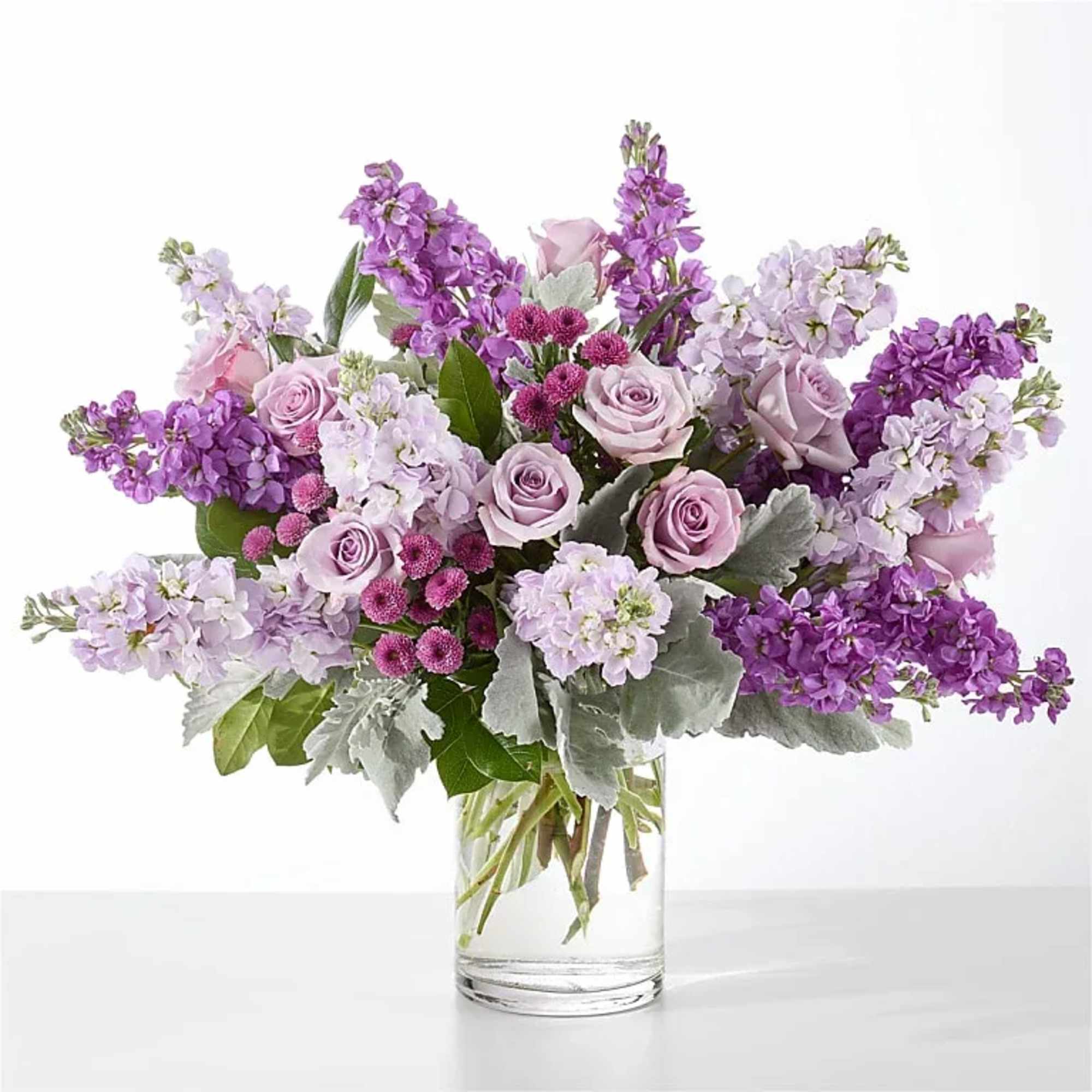 Clusters of lavender roses sit among tall purple and lavender stock, accented