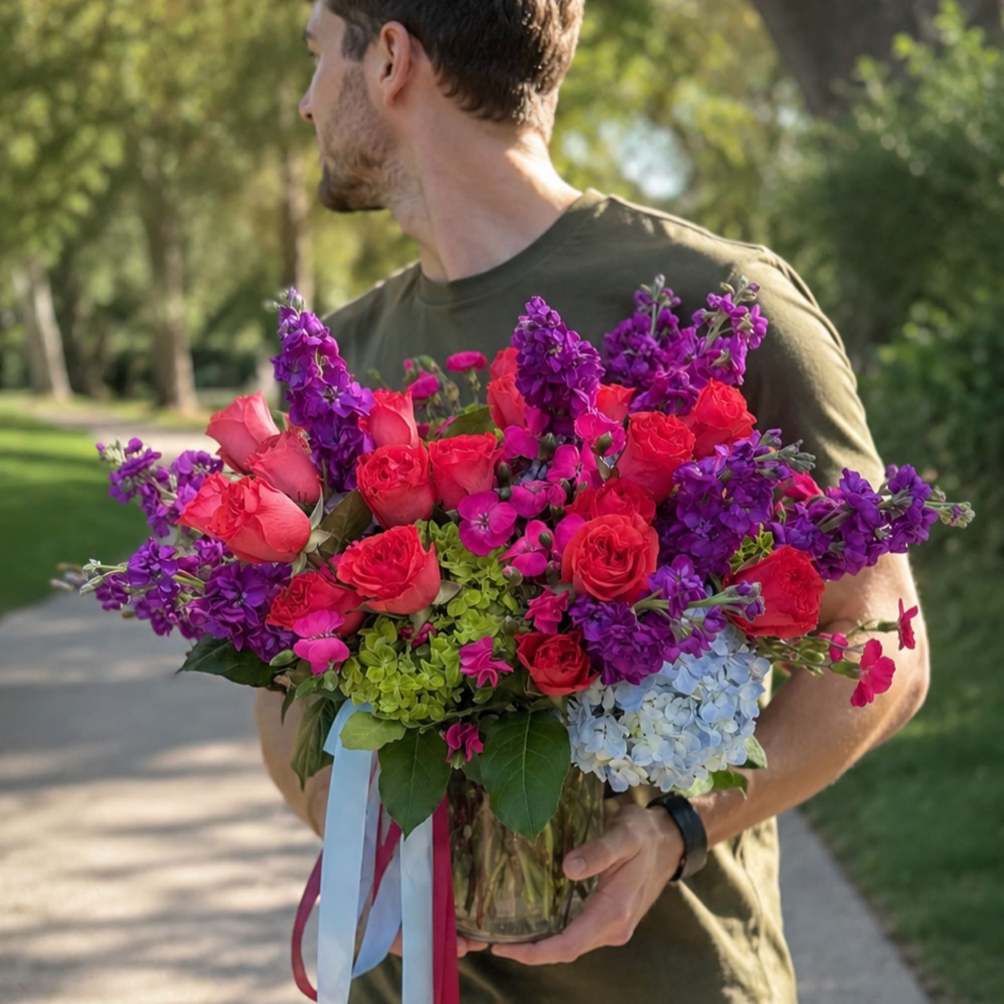 Vivid magenta roses and towering purple stock give this flower arrangement an