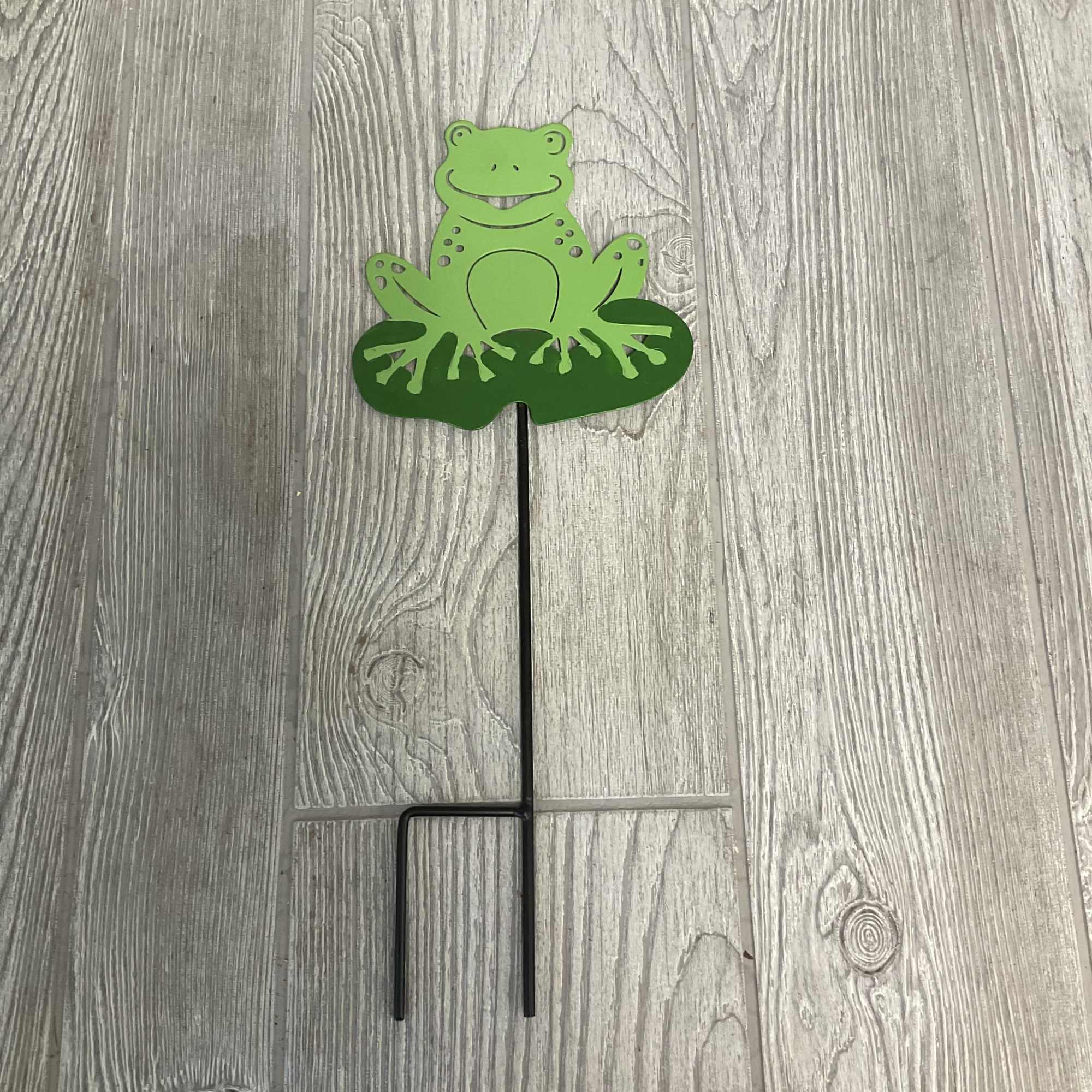 Green frog-shaped garden stake with a black metal support