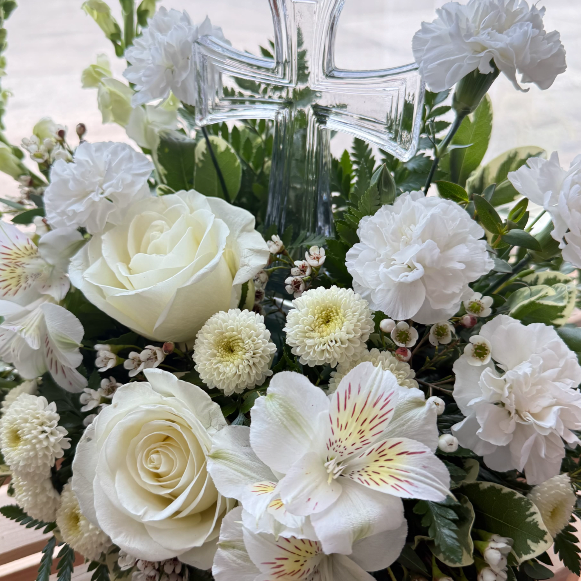 A front-facing arrangement featuring white blooms with an 8.5-inch crystal cross keepsake.