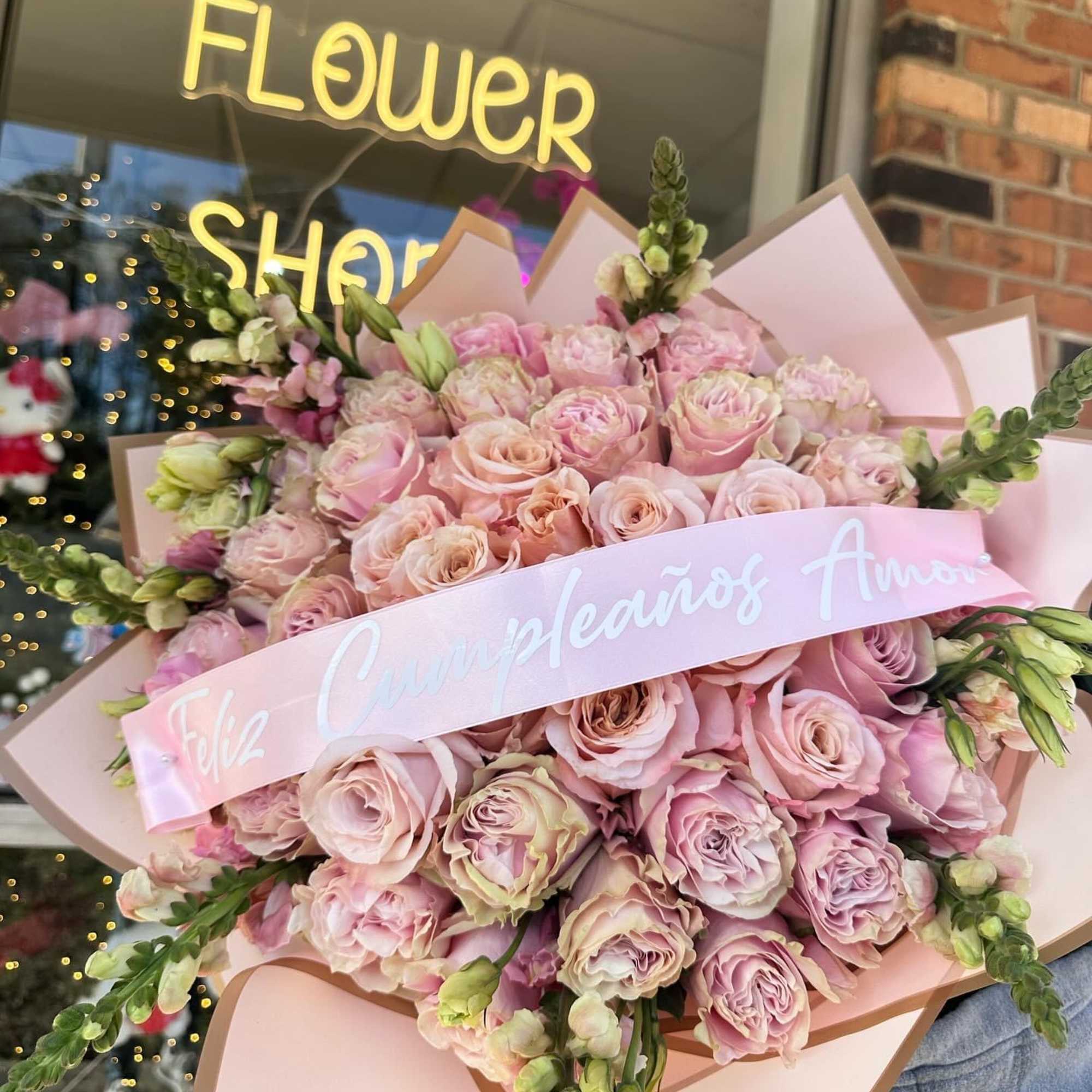 Large bouquet of pale pink roses wrapped in pink paper