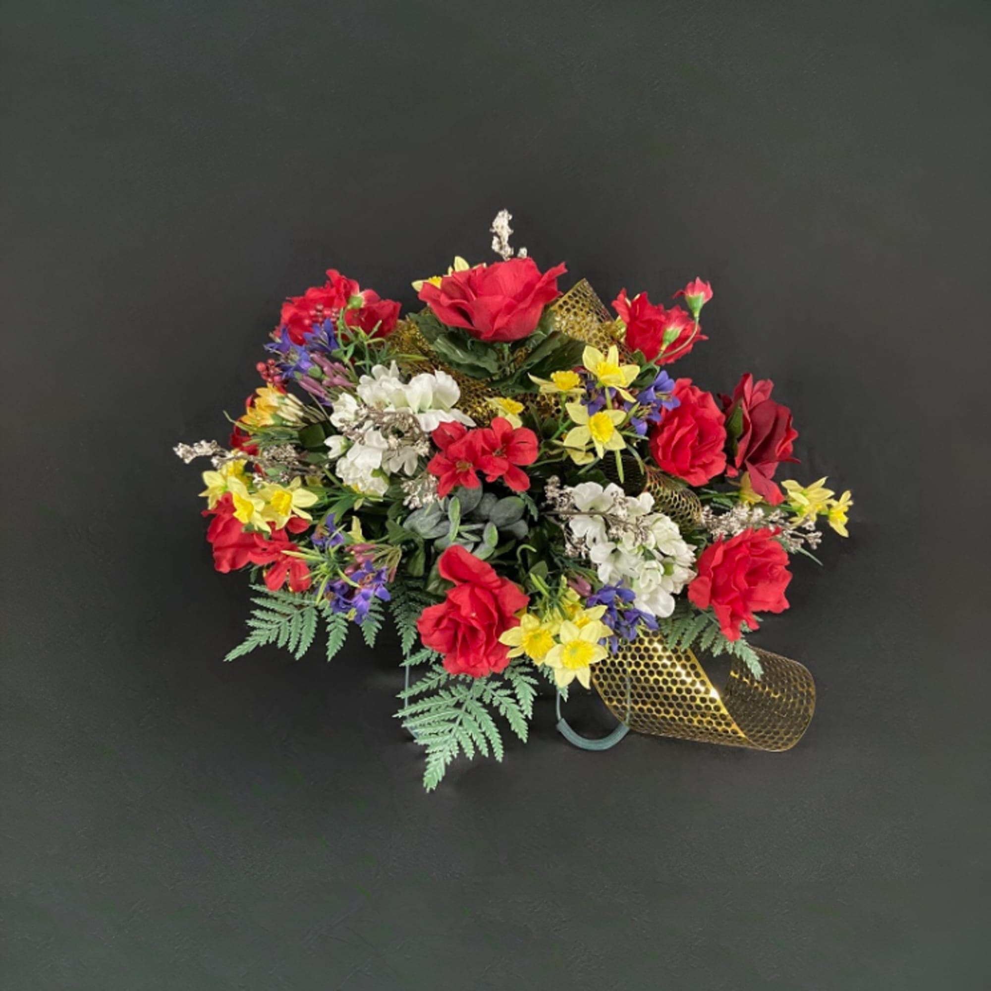 Colorful bouquet of red, white, yellow, and purple flowers with gold ribbon
