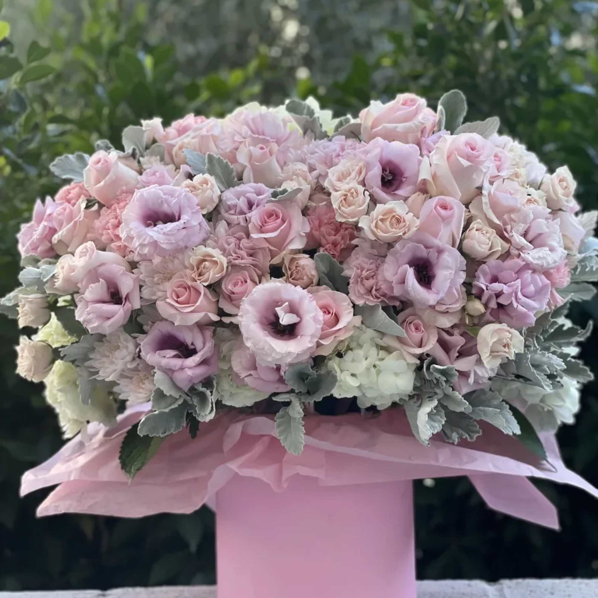 A plush dome of blush and lavender florals artfully arranged in a