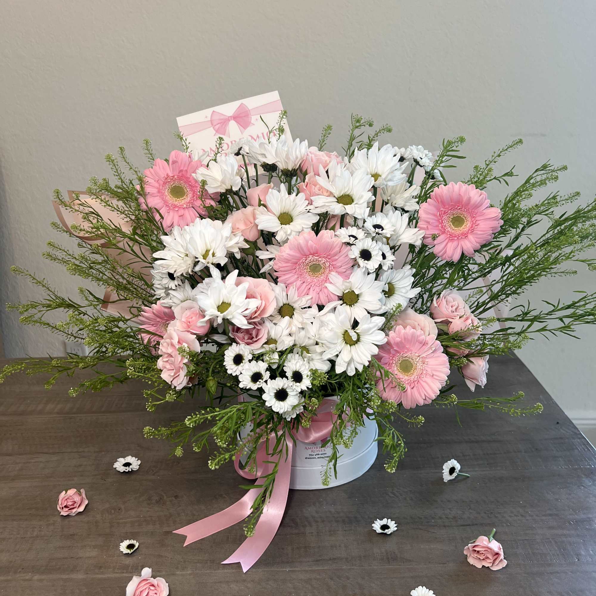 Pink and white flower arrangement in a white hat box with ribbon