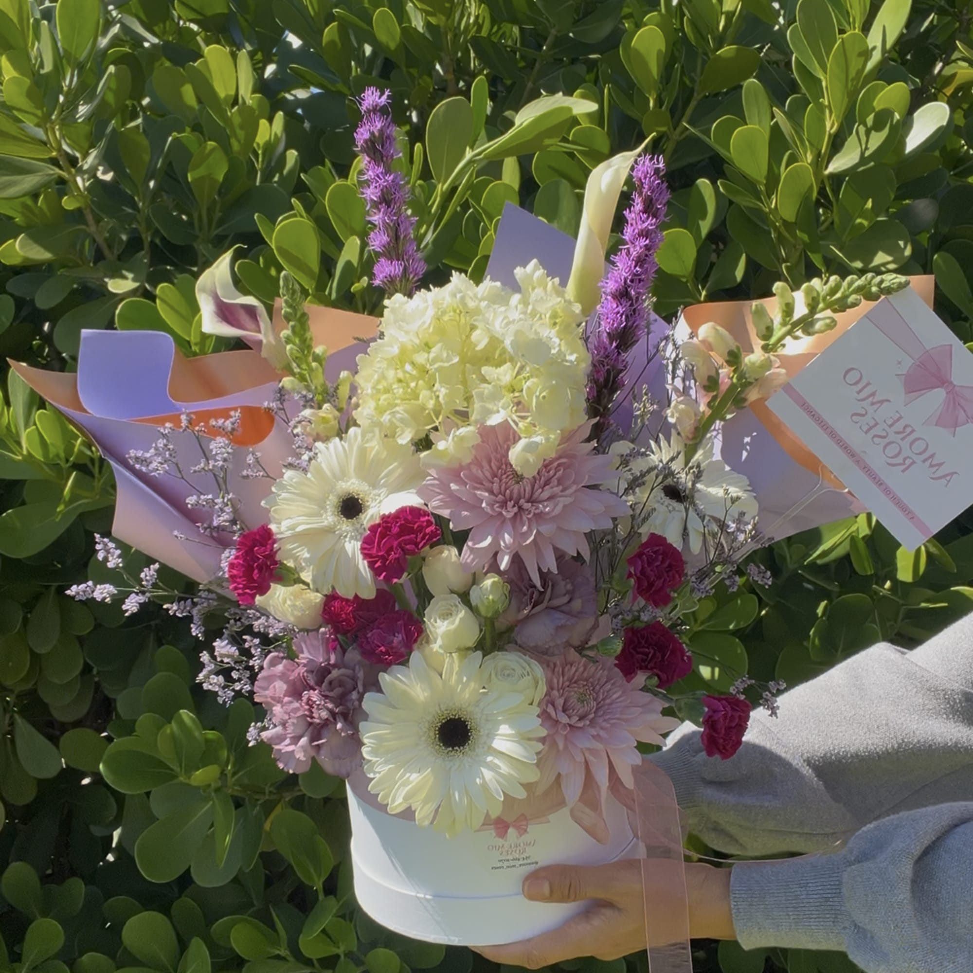 Bouquet of pink, white, and purple flowers in a white hatbox