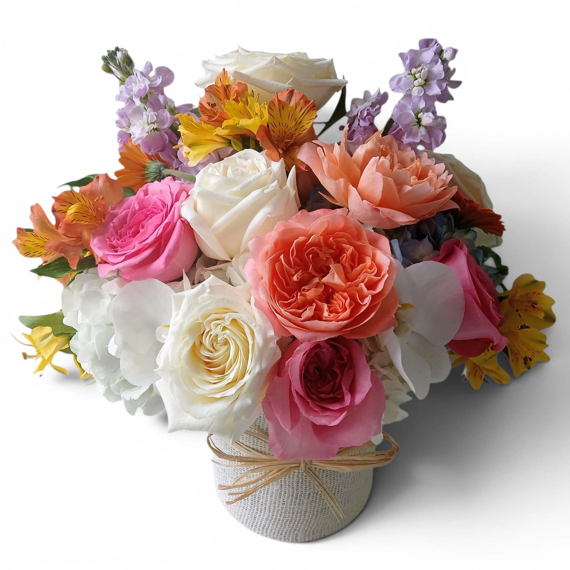 Mixed bouquet of roses, orchids, and alstroemeria in a wrapped container