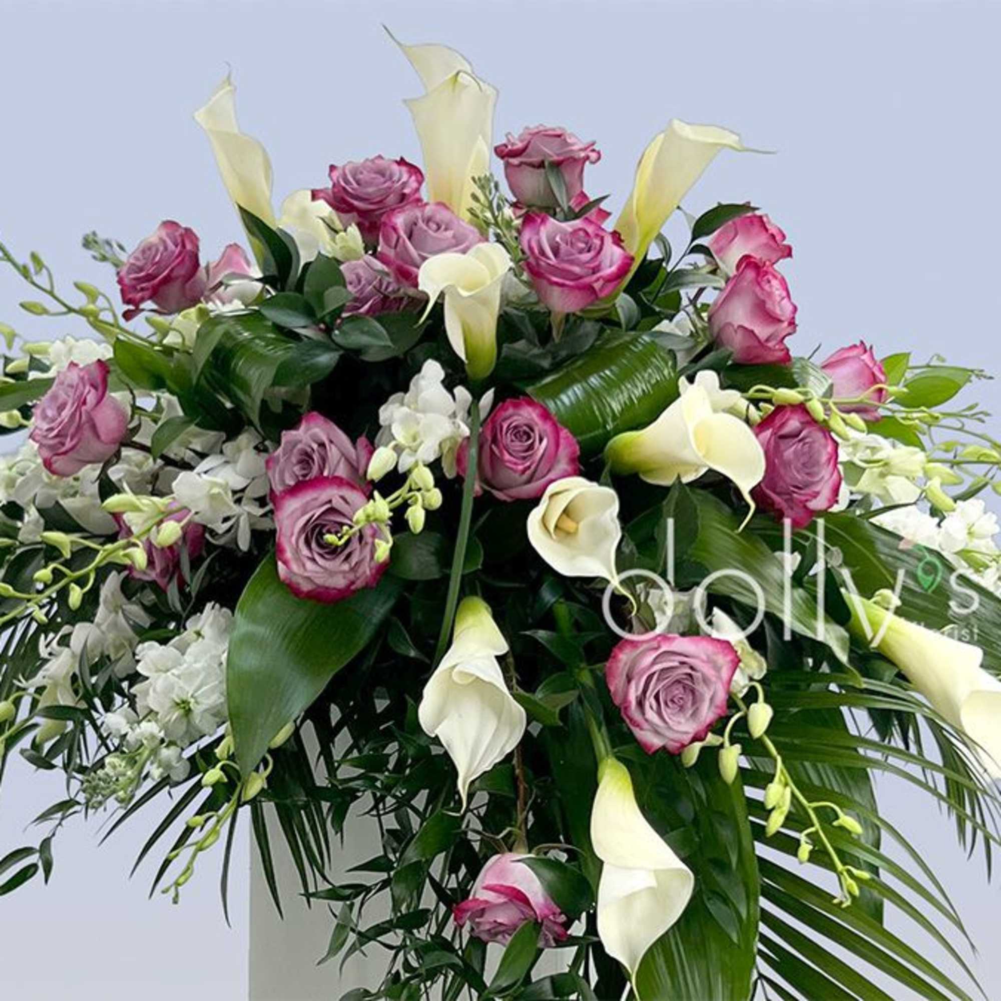 A dramatic cascading spray of magenta roses and ivory calla lilies designed