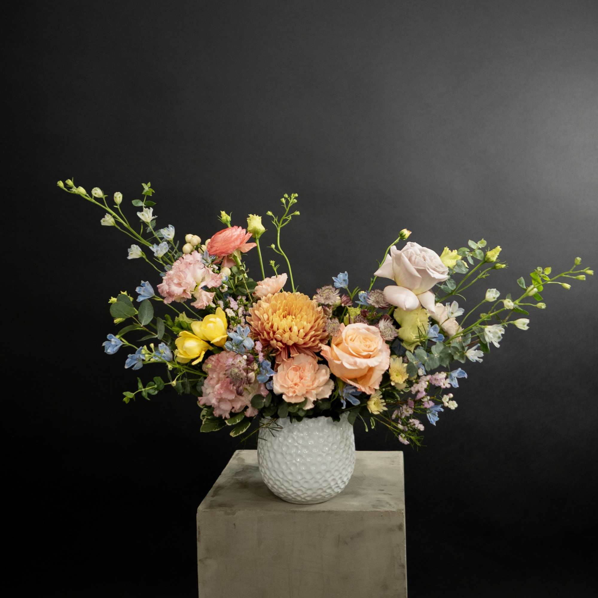 Mixed bouquet in a white textured vase