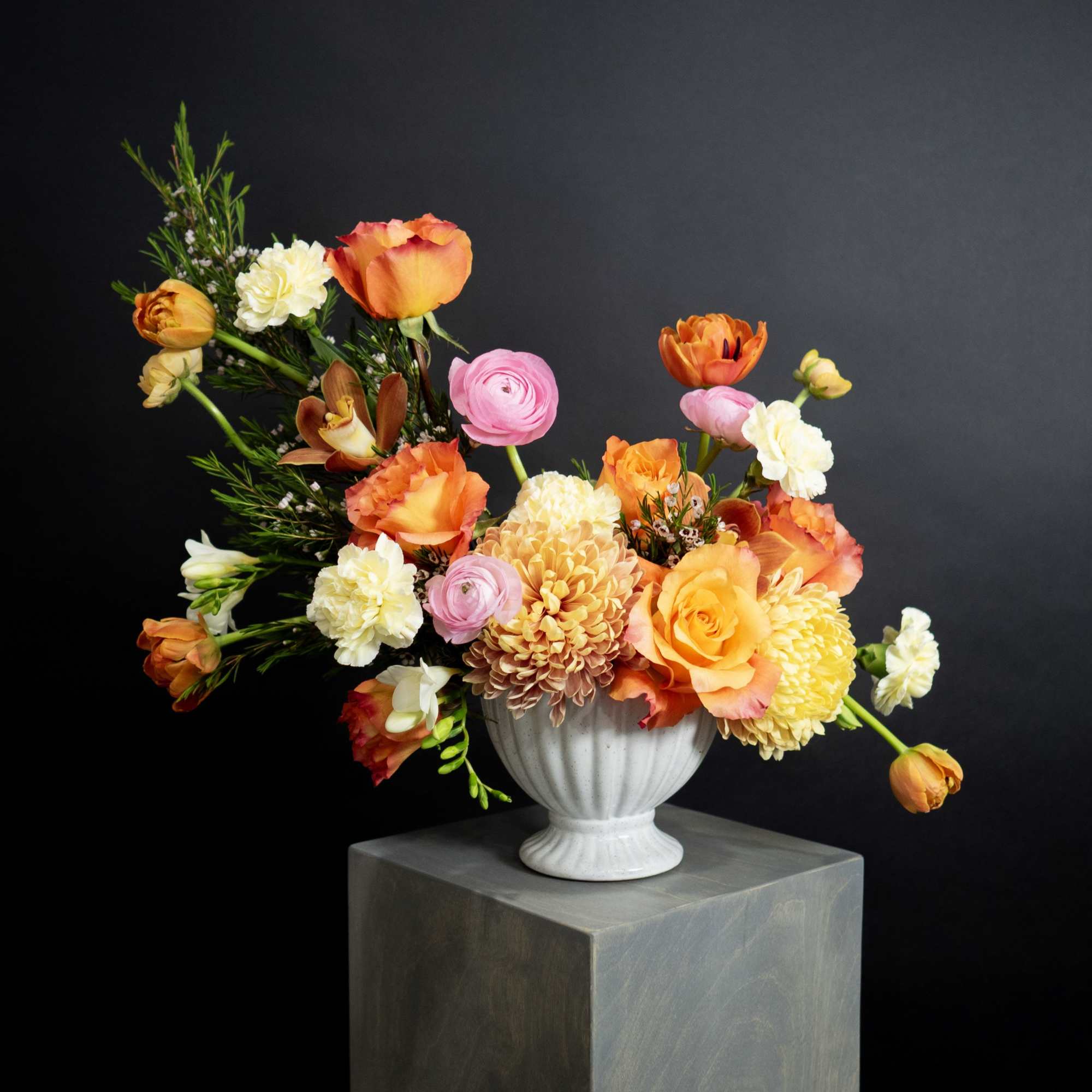 Colorful mixed flower arrangement in a white vase