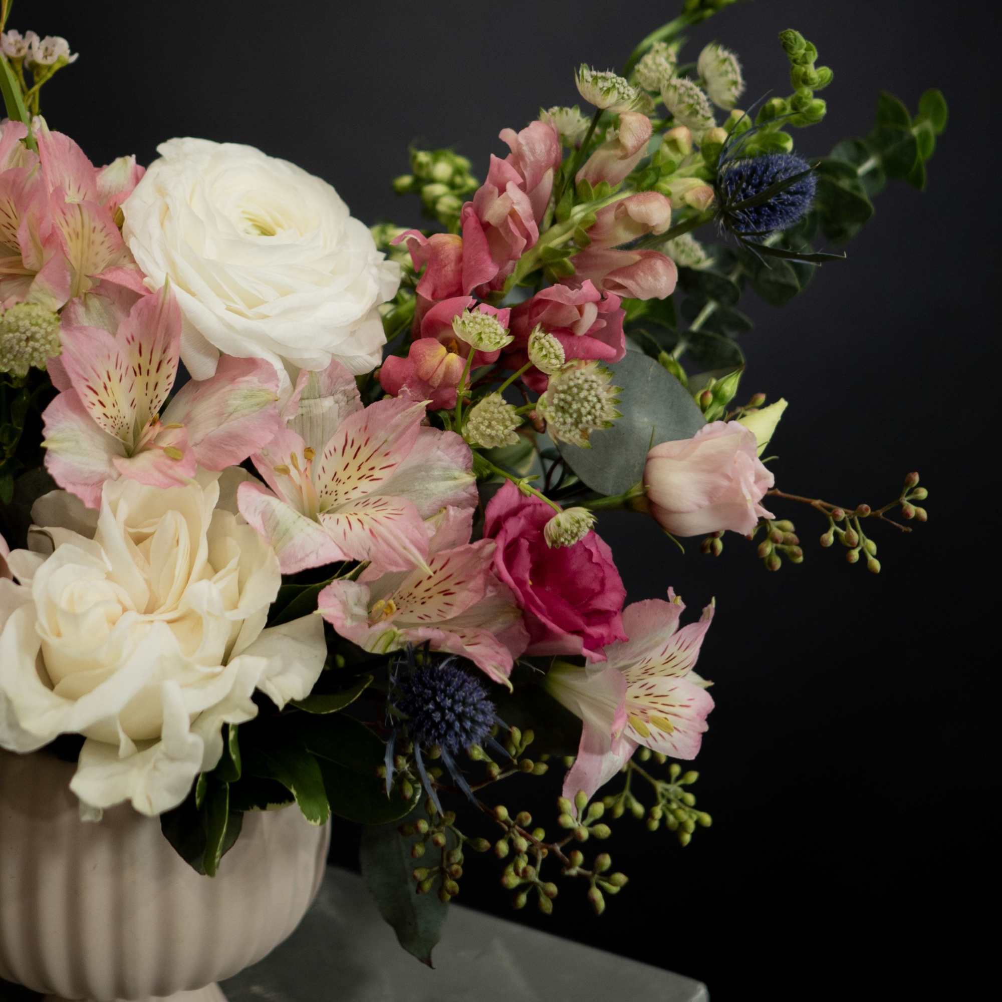 Pink and white bouquet in a ribbed ceramic vase