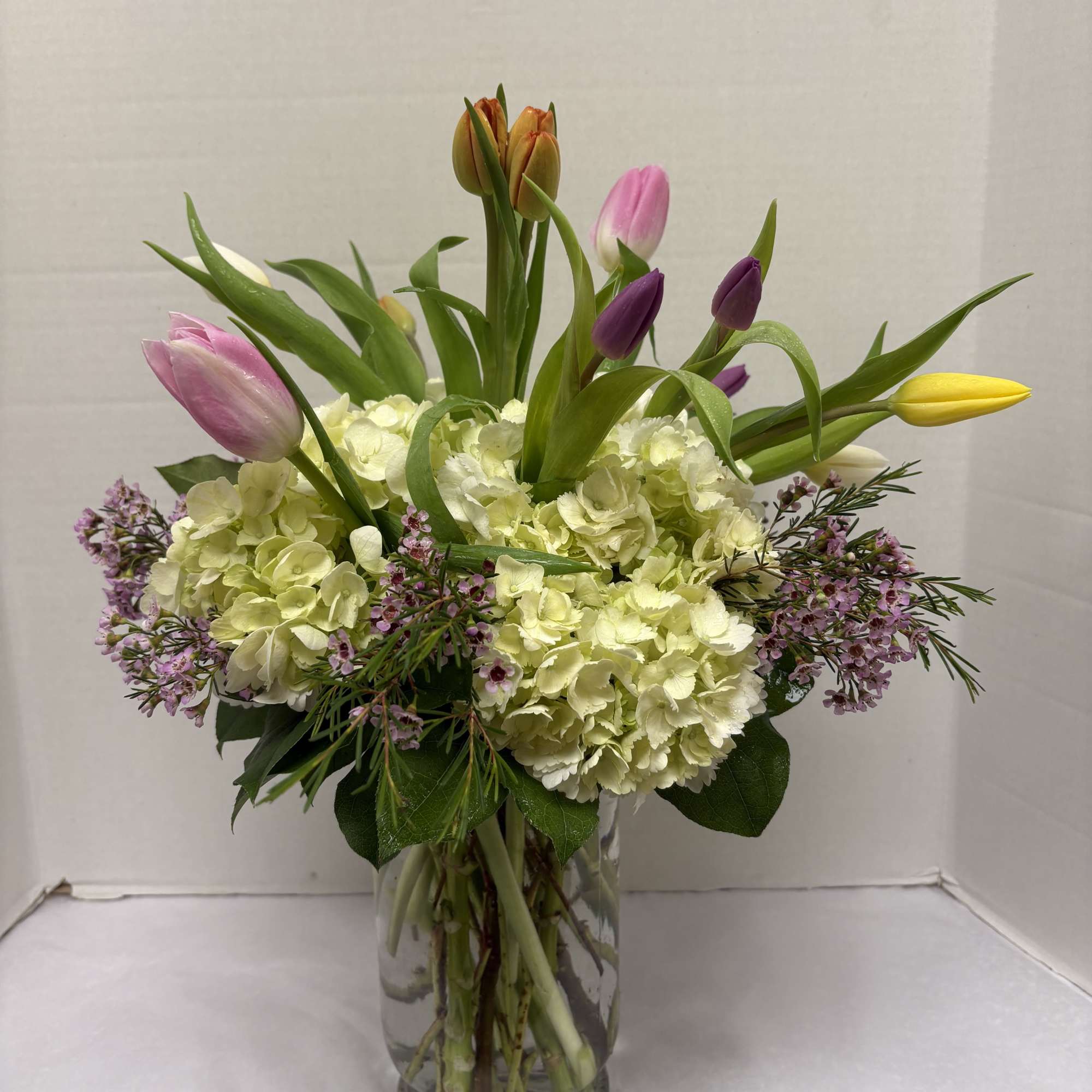 A luminous cushion of pale ivory hydrangeas forms the foundation of this