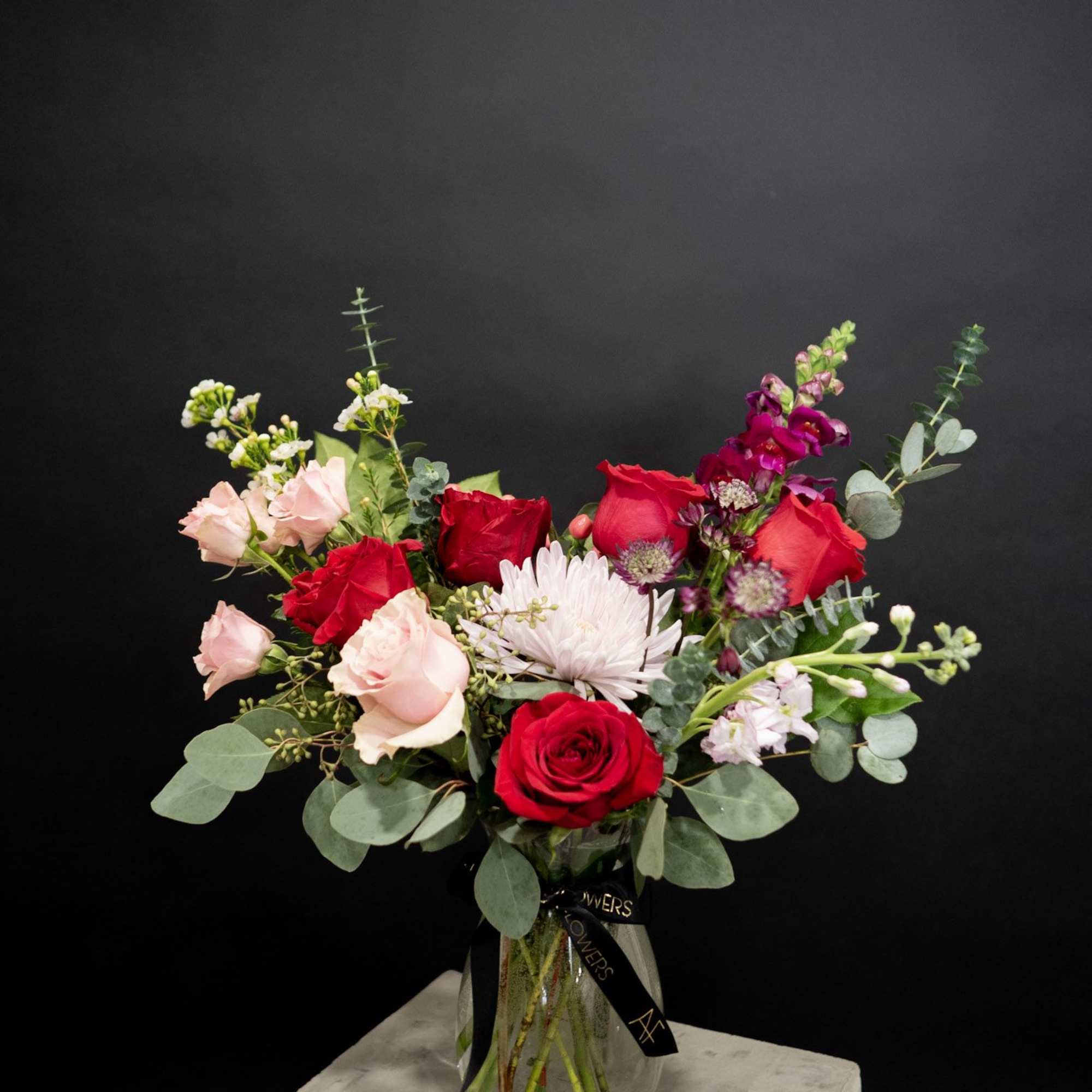 Bouquet of red and blush roses in a glass vase